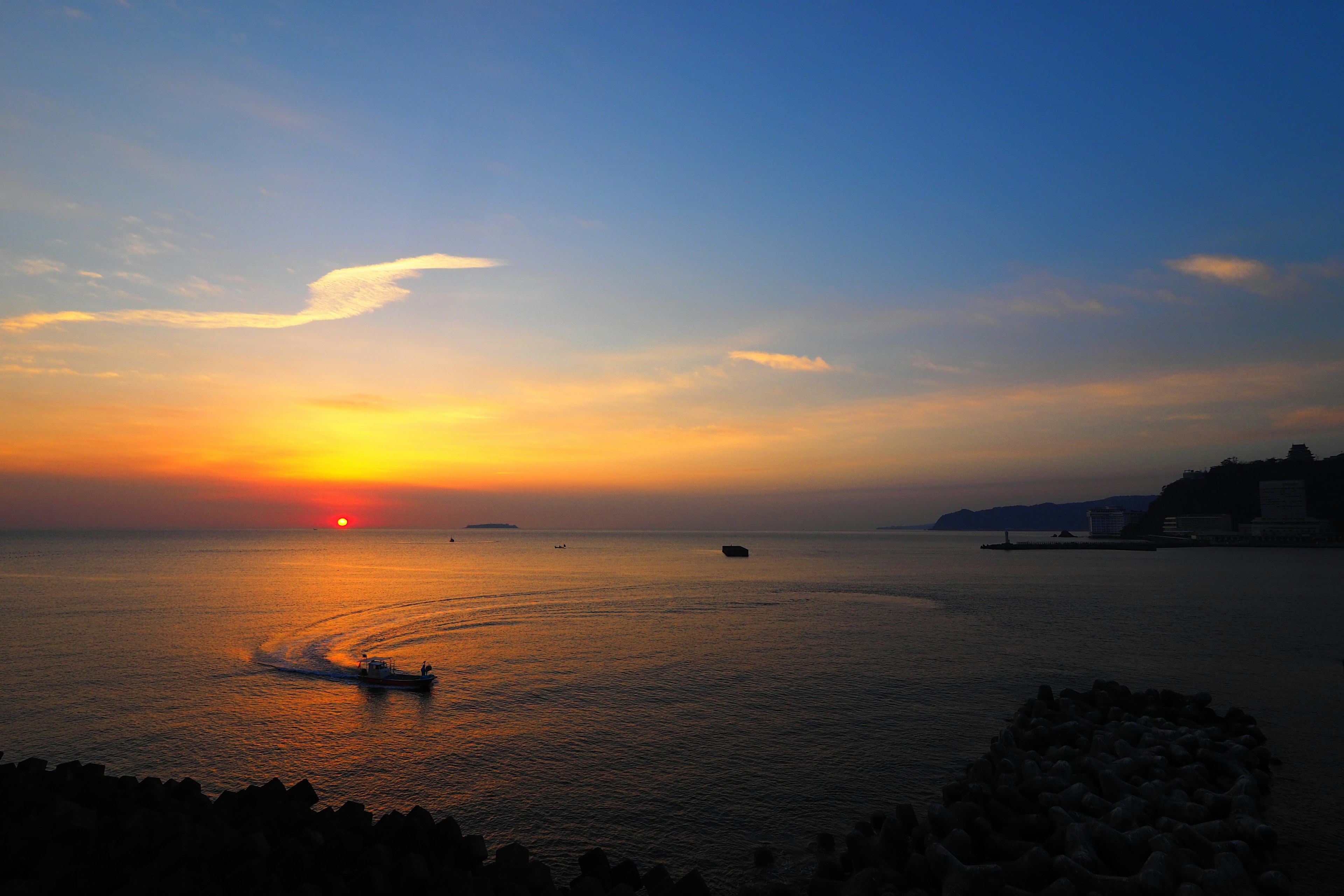 Magnifique coucher de soleil sur la mer avec un bateau voguant tranquillement