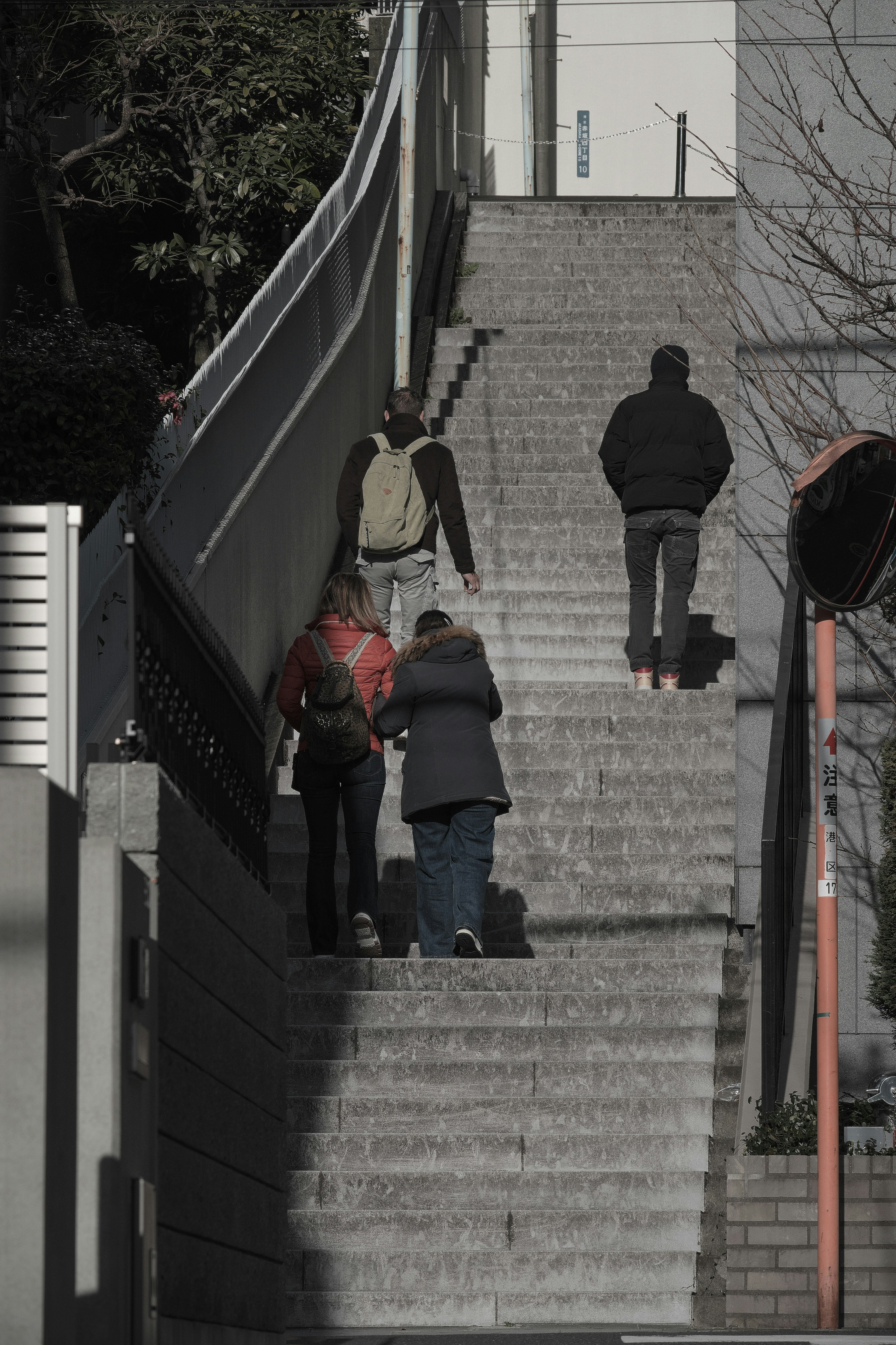 Persone che salgono le scale con edifici circostanti