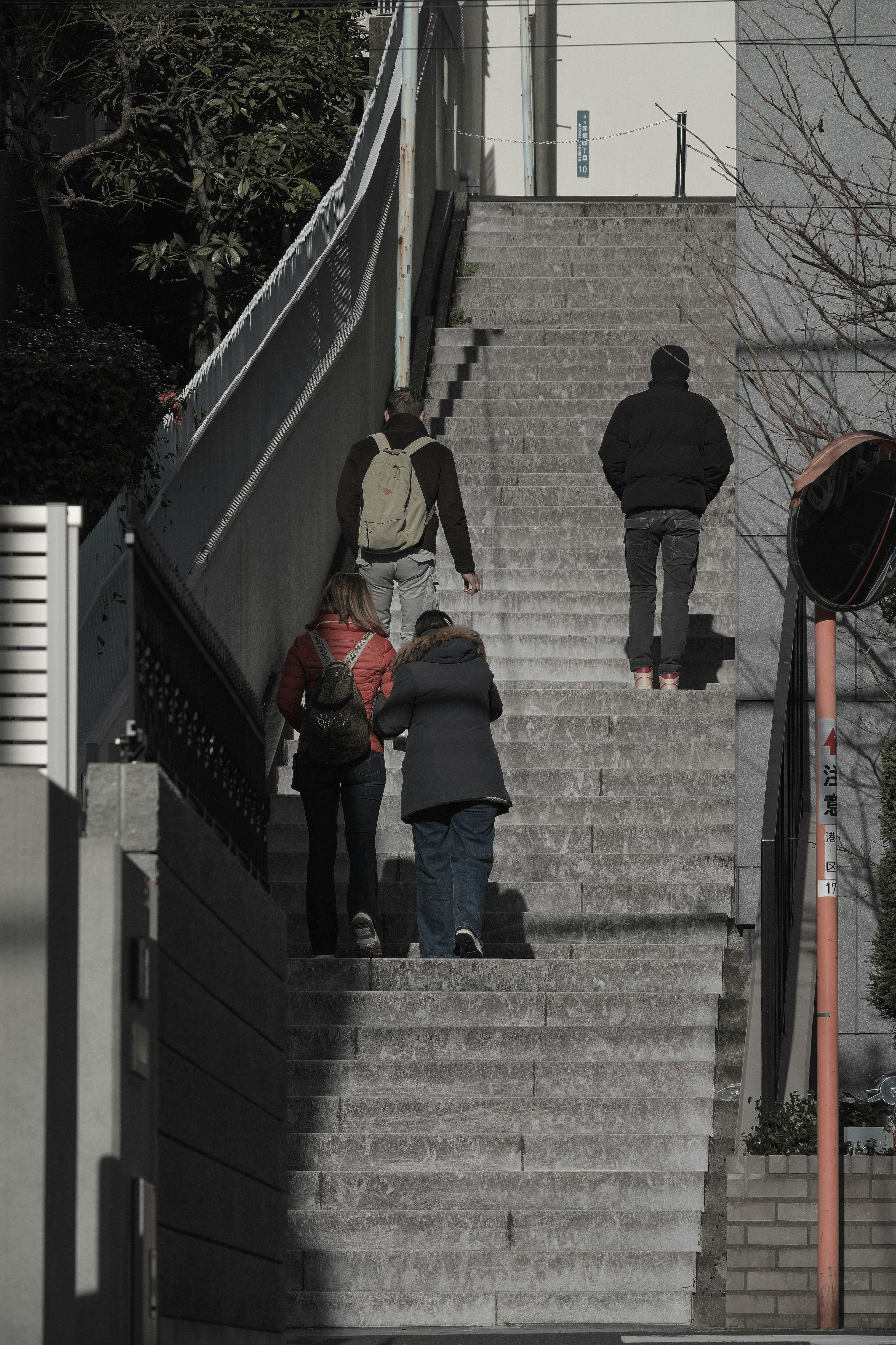 階段を上る人々の後ろ姿と周囲の建物