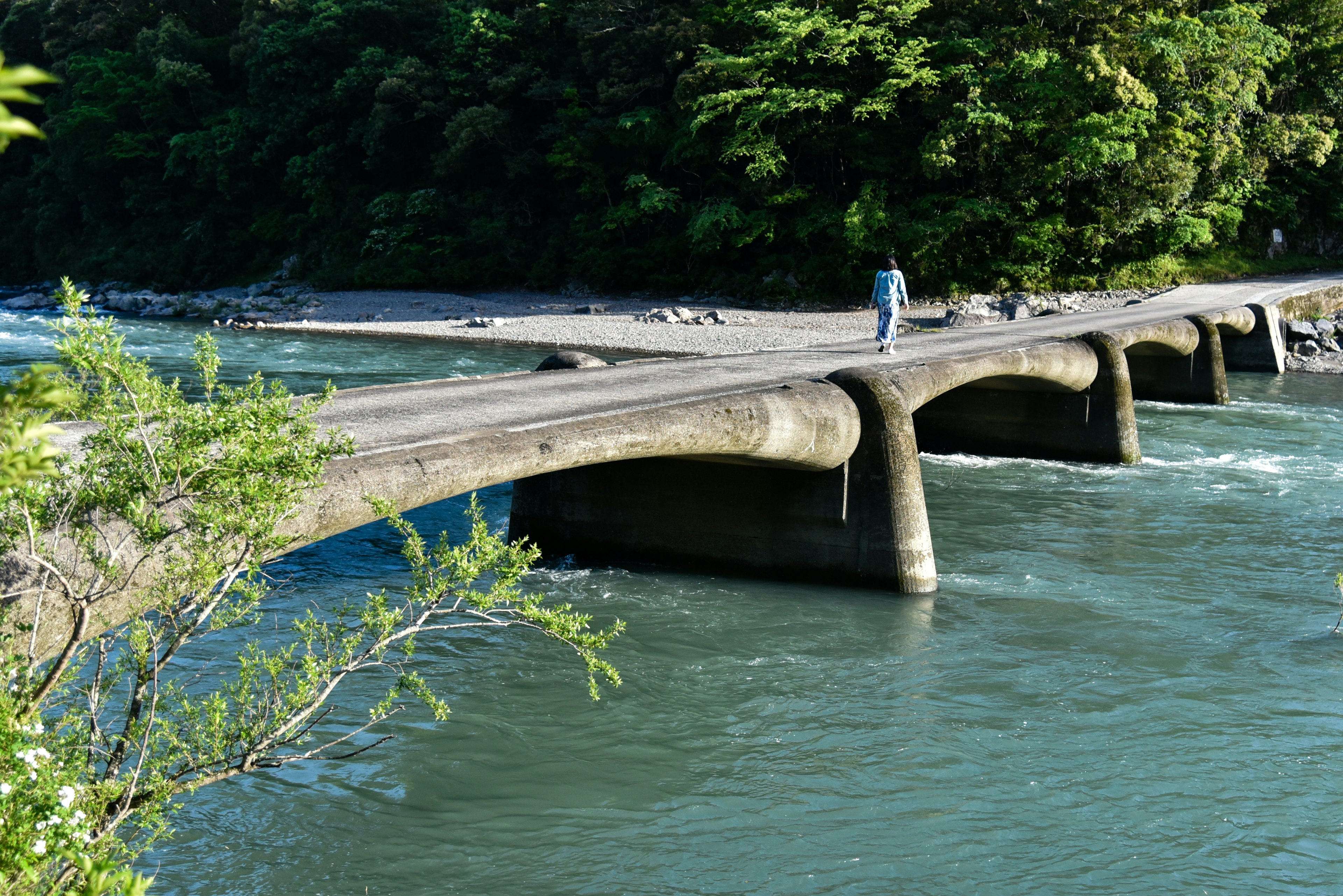 Betonbrücke über einen Fluss mit üppigem Grün in der Umgebung