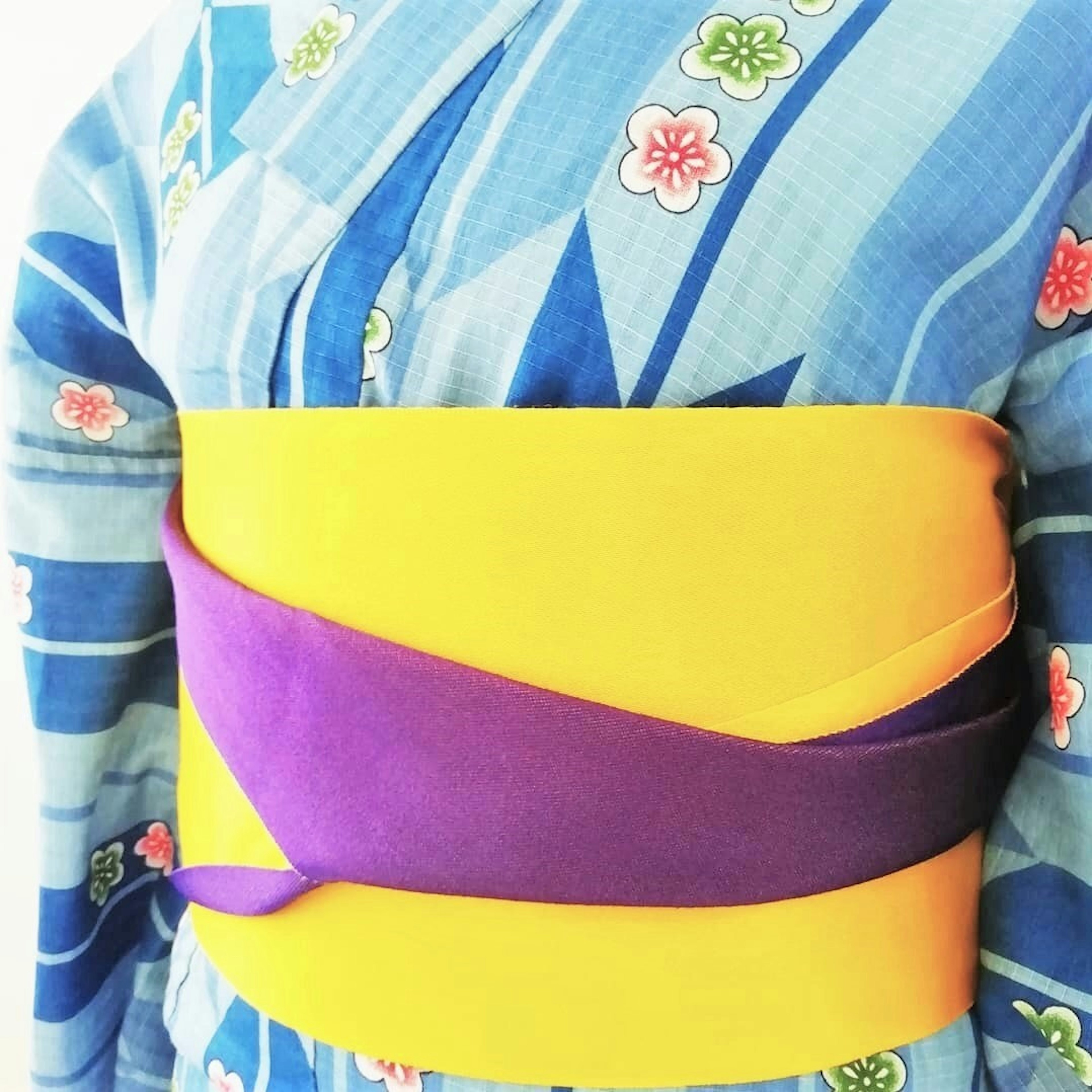 Kimono bergaris biru dengan pola bunga berwarna-warni dan obi kuning dan ungu