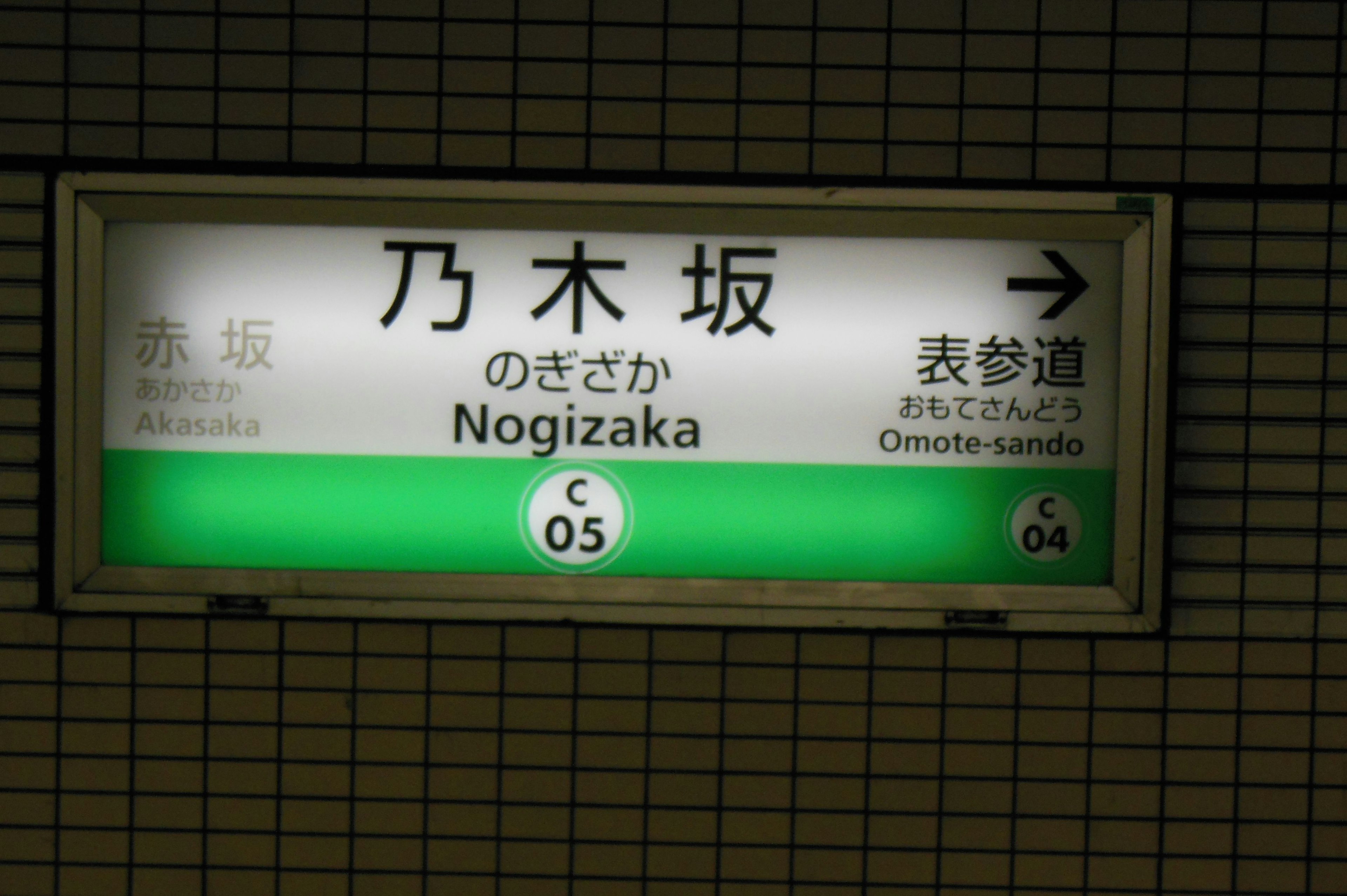 Insegna della stazione Nogizaka con sfondo verde e testo bianco