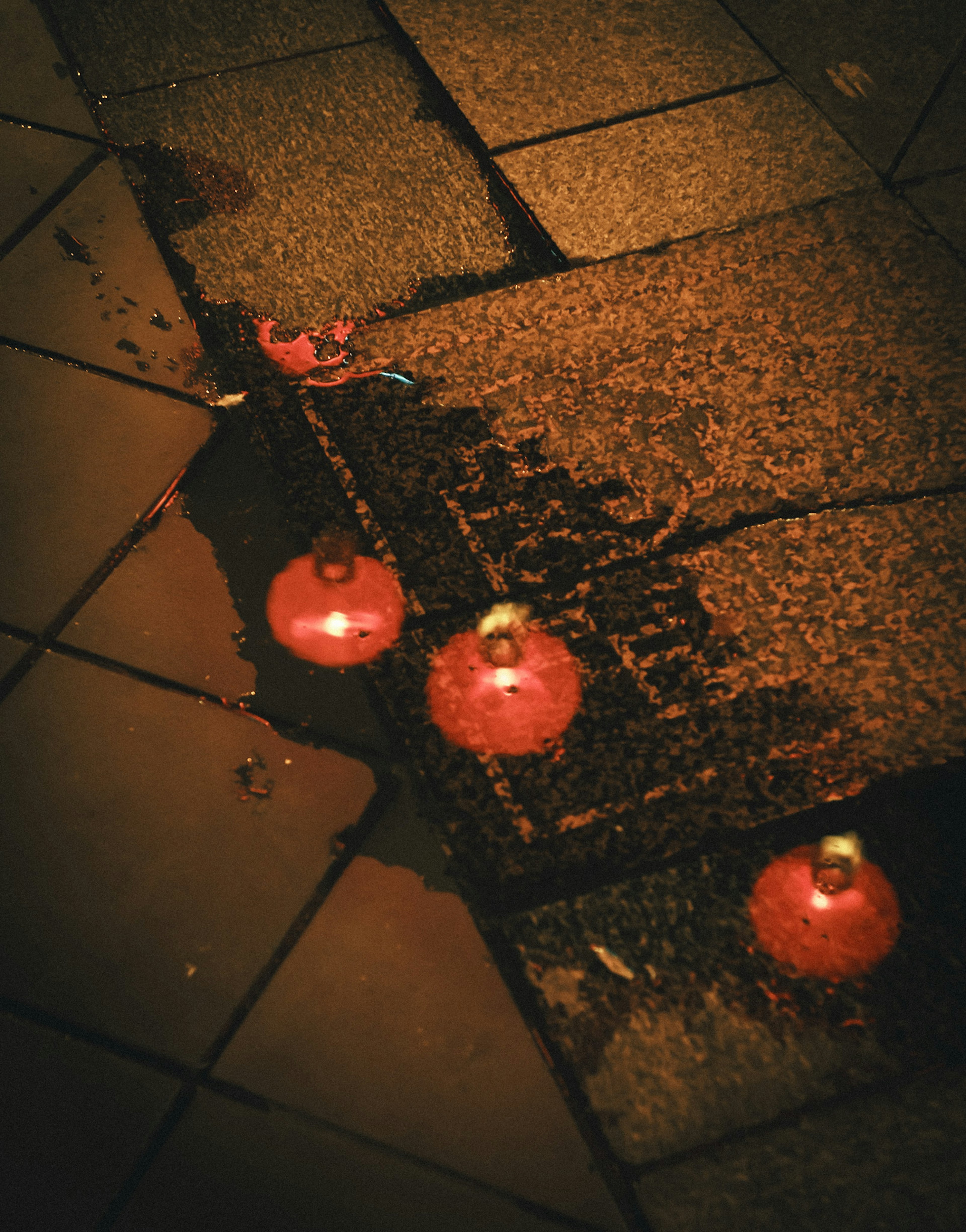 Adornos rojos esparcidos en una calle pavimentada por la noche