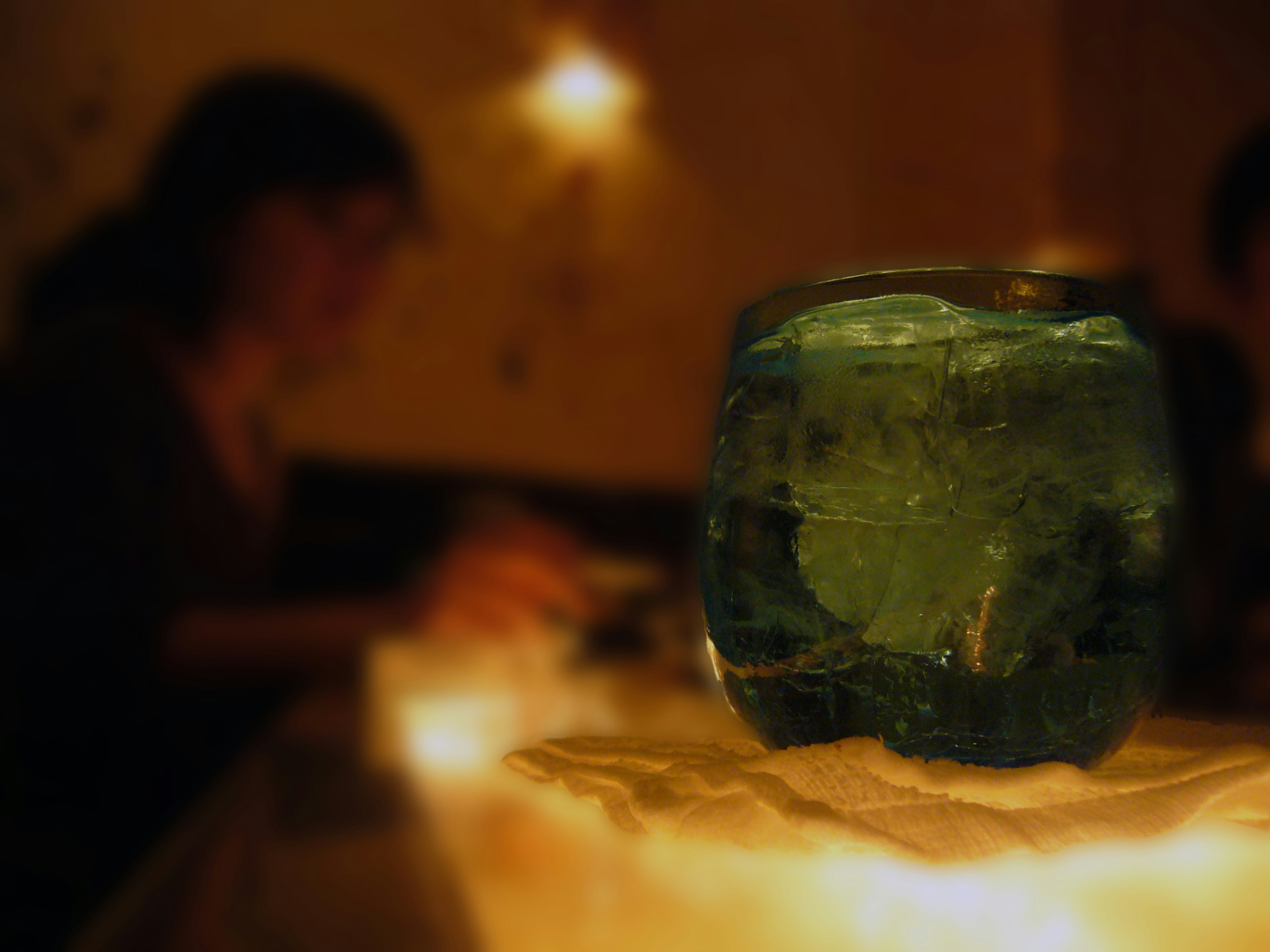 A close-up of a blue ice block on a table with a blurred background