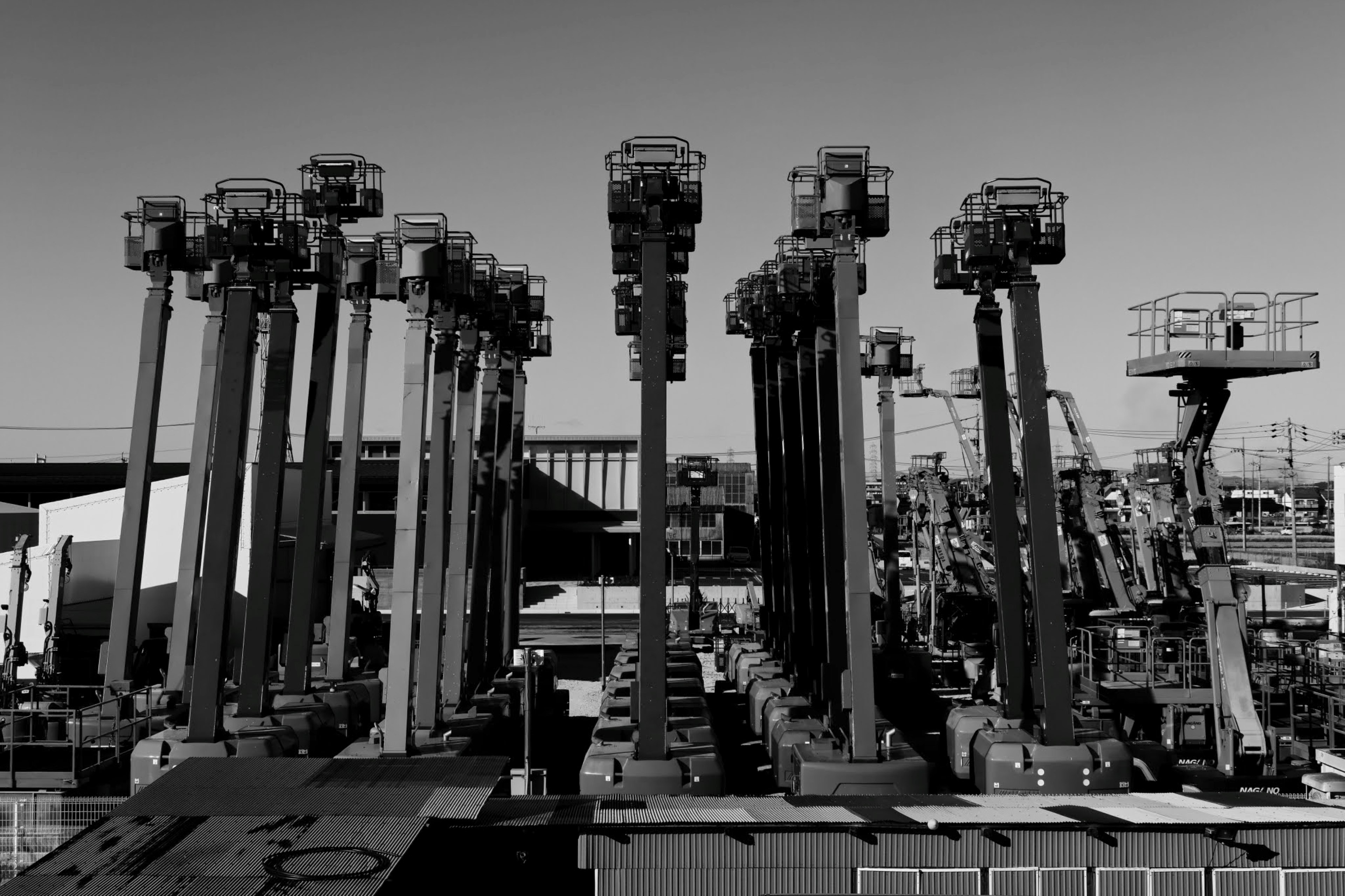 Fila de grúas altas en un entorno industrial en blanco y negro