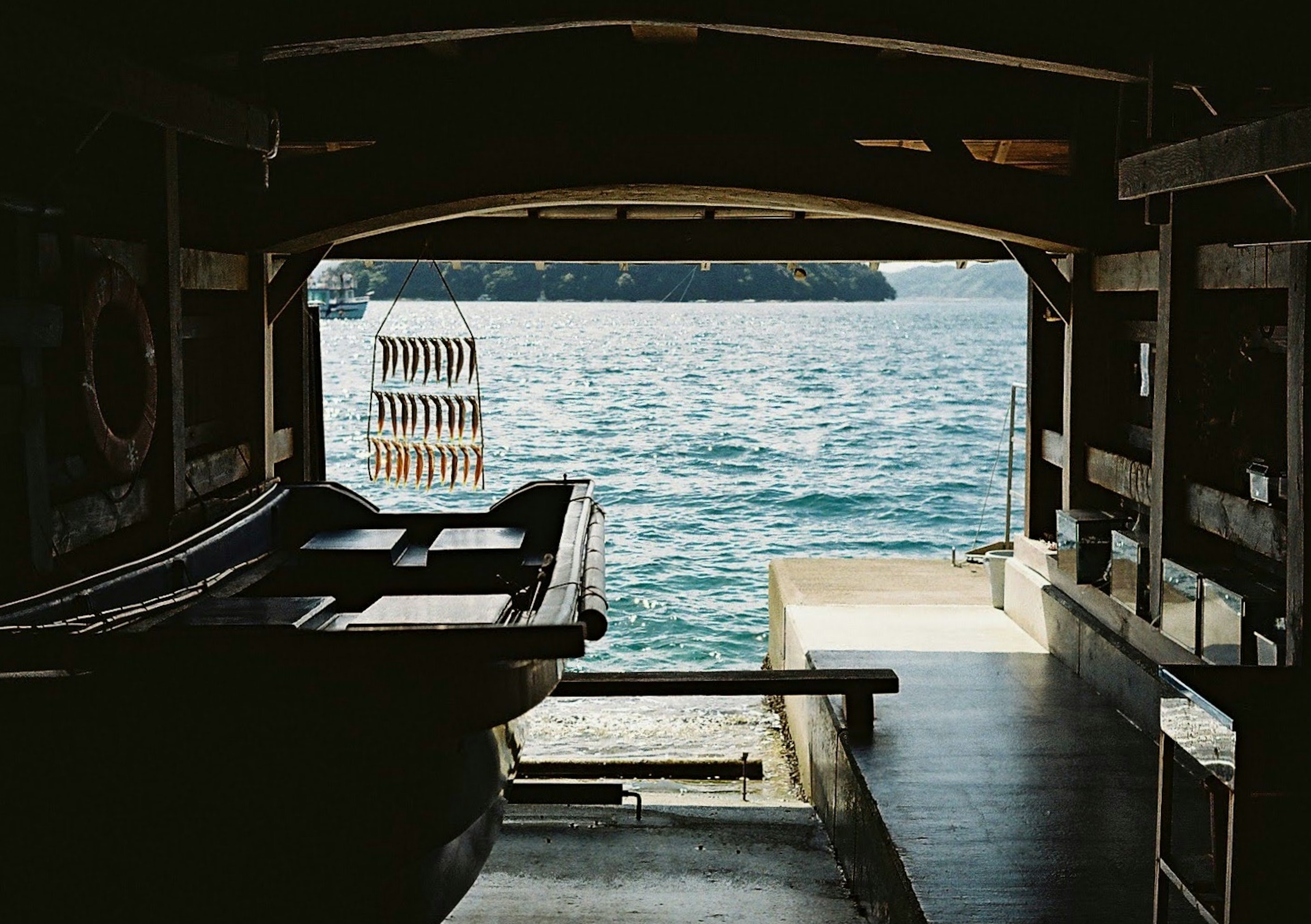 Blick auf das Meer von innen eines Bootes mit Holzstruktur