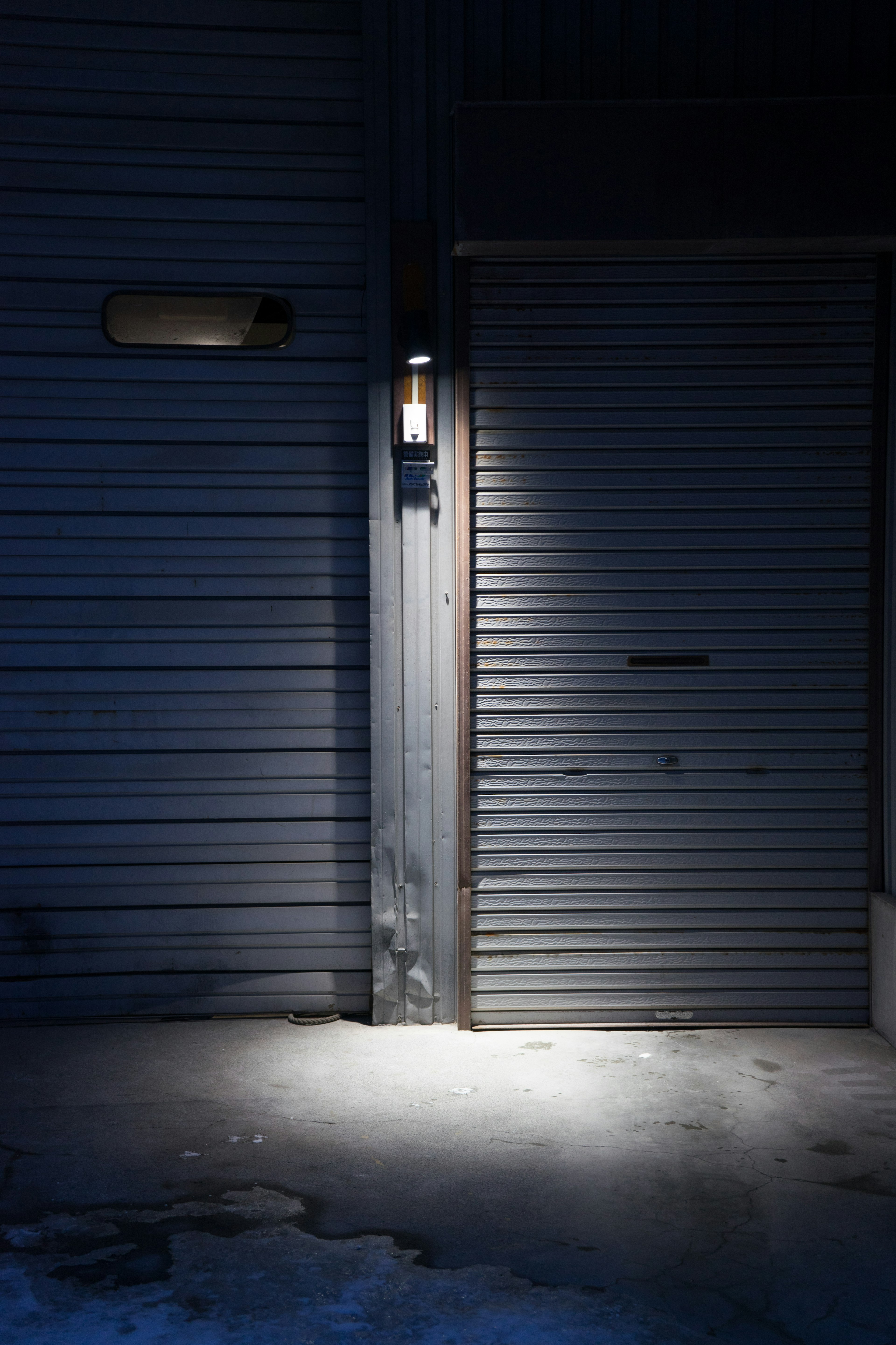 Metal door and wall illuminated against a dark background