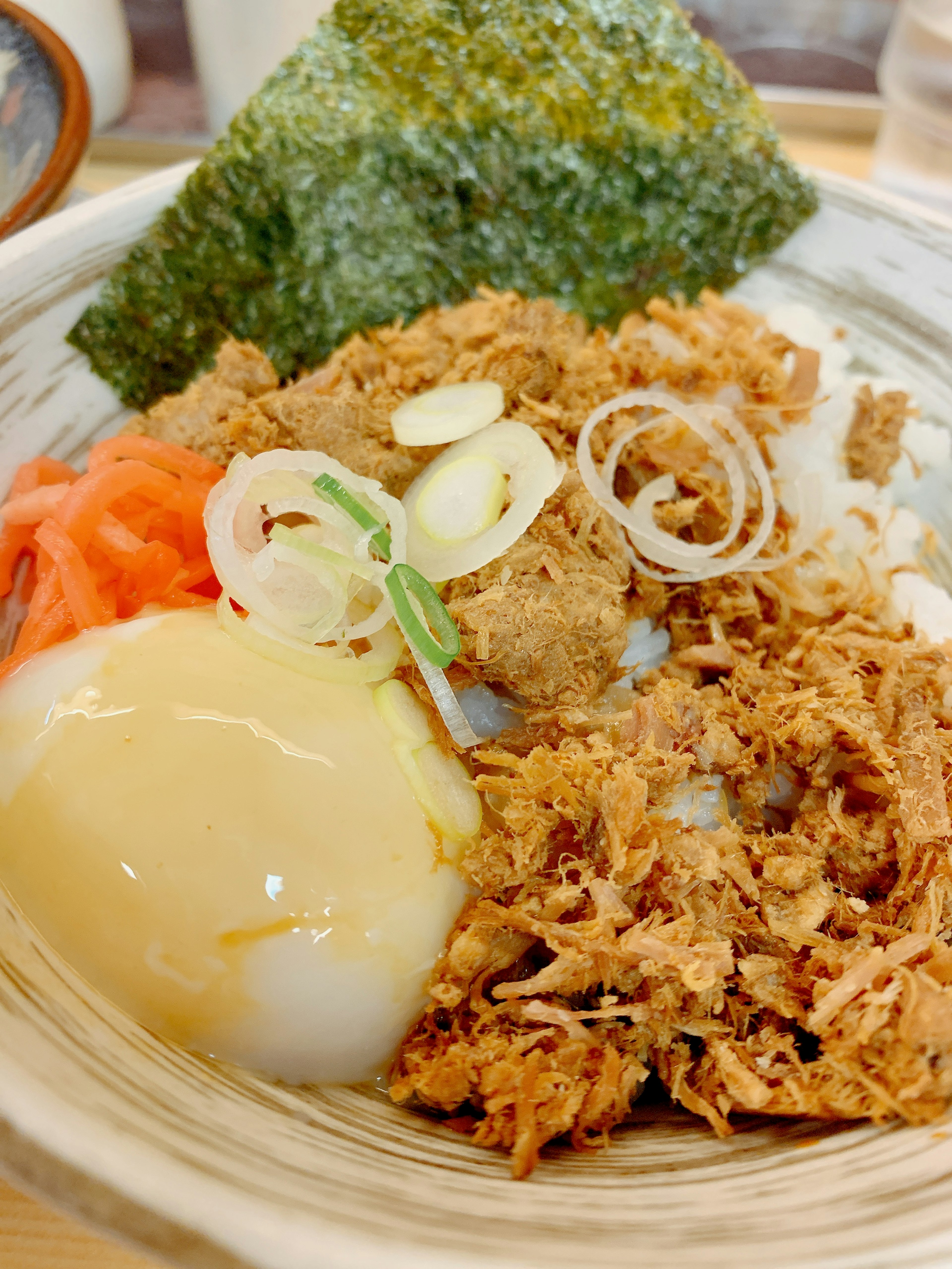 Bowl of rice topped with crispy fried chicken and soft boiled egg