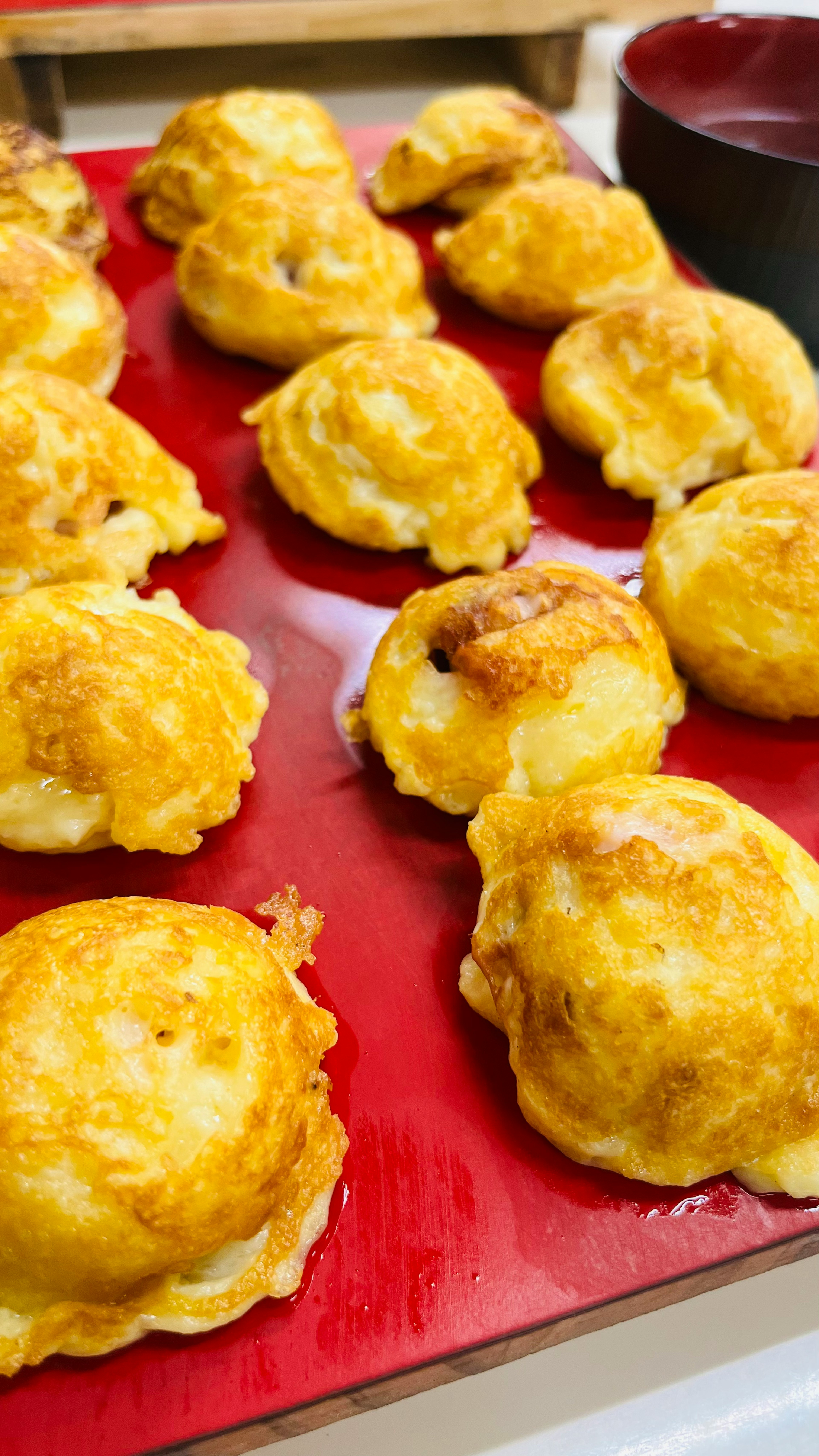 Bocadillos en forma de bola esponjosos recién horneados dispuestos en un plato rojo