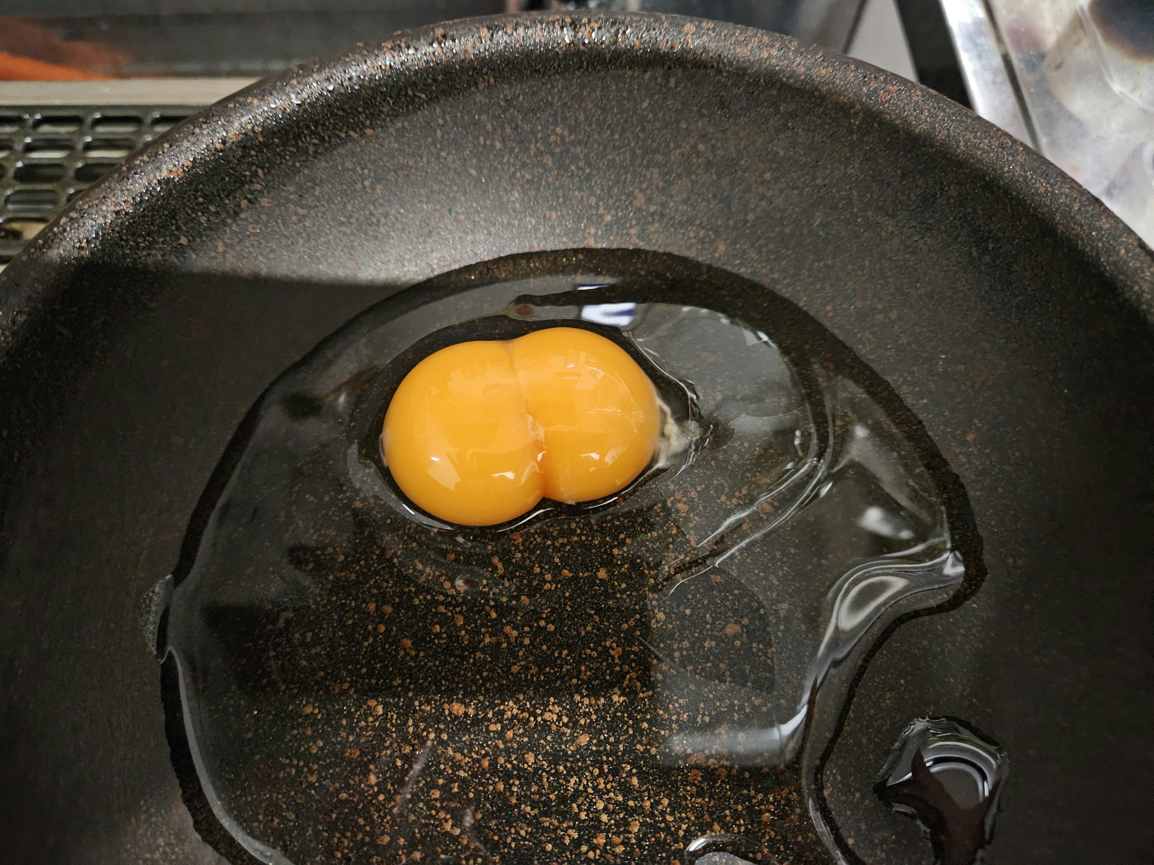 A frying pan with two egg yolks