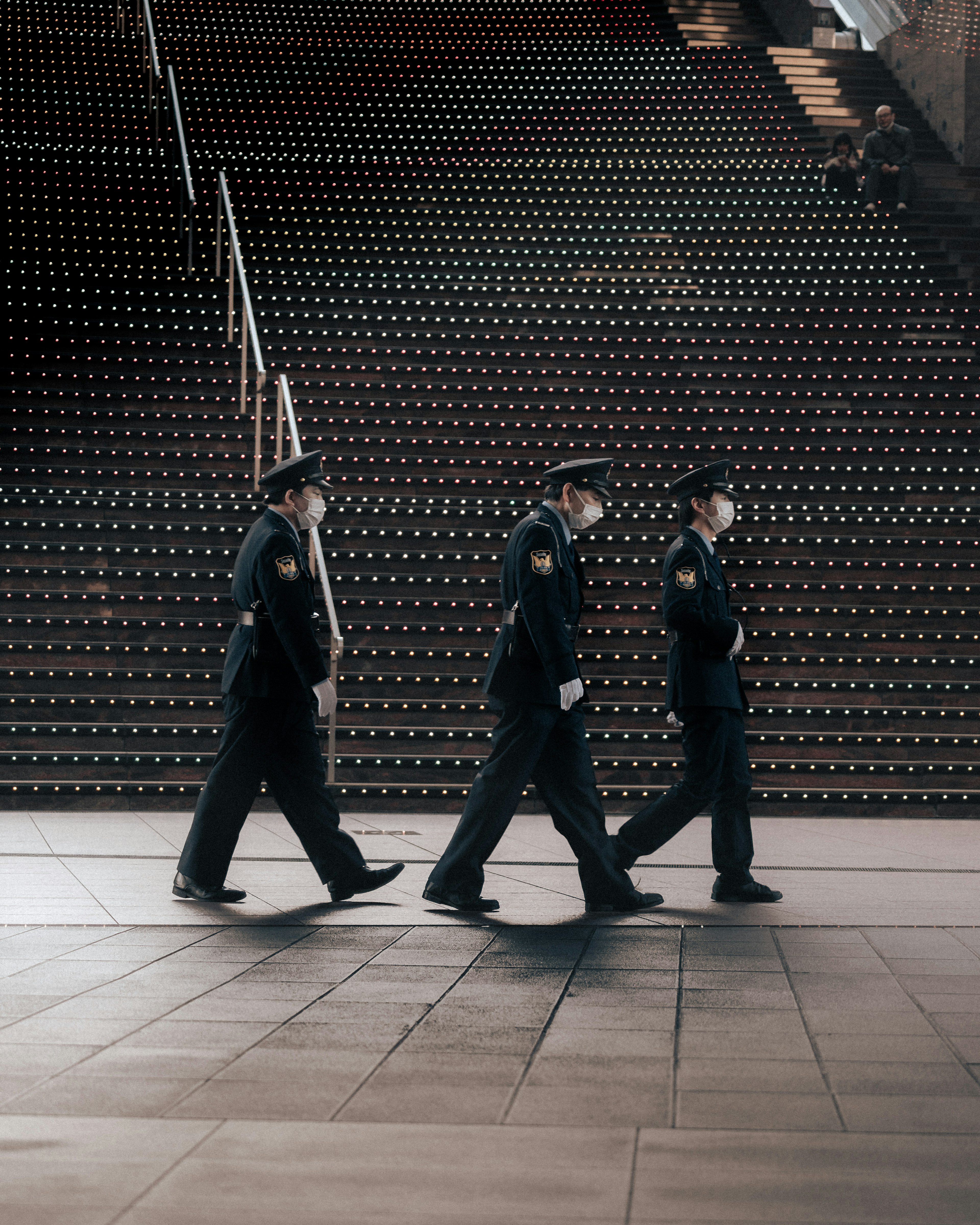 Three police officers walking down a staircase