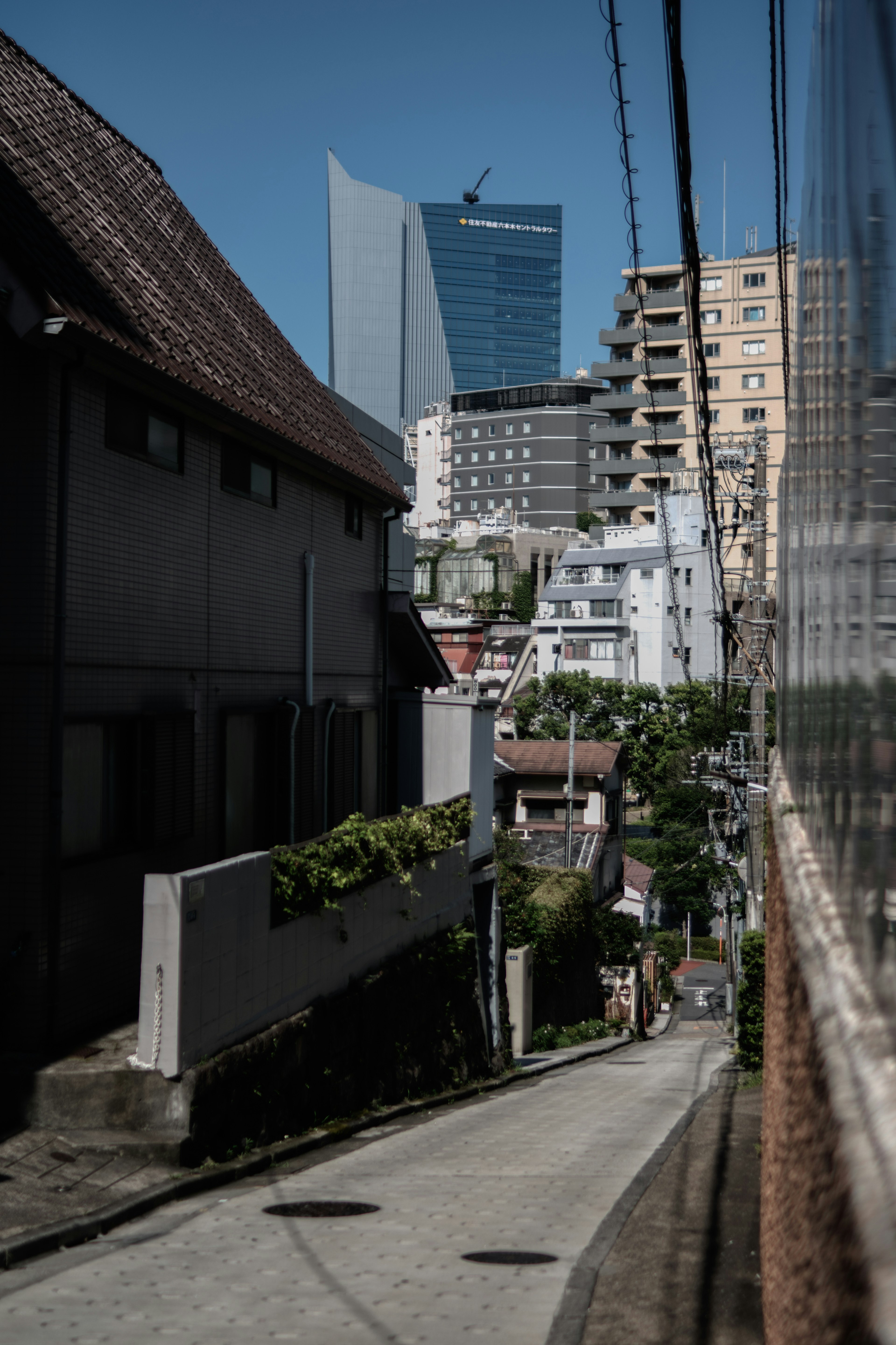 Pemandangan jalan dengan campuran rumah tradisional dan gedung pencakar langit modern