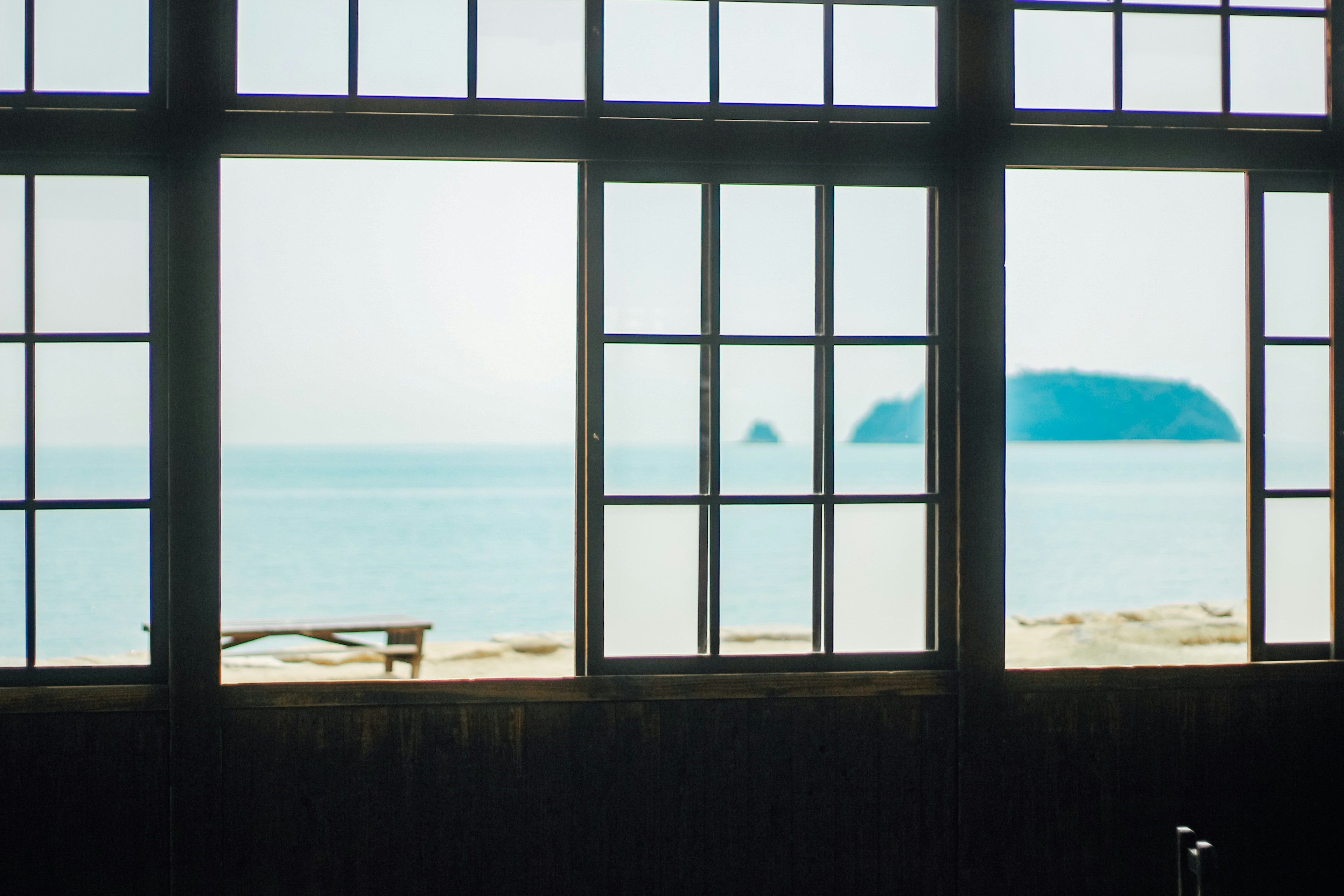 Interior view through windows showing a serene ocean landscape