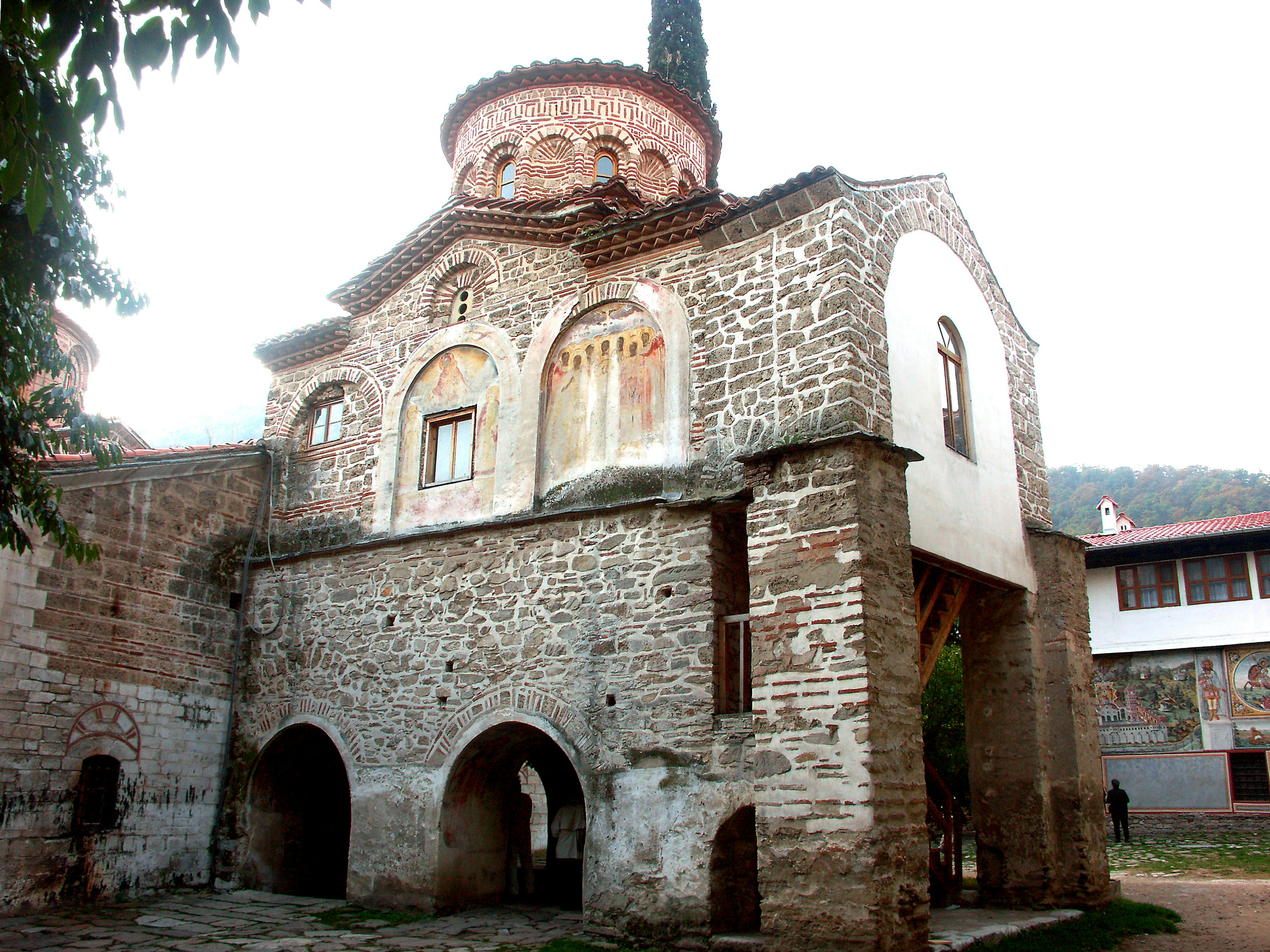 Edificio histórico de piedra con cúpula y ruinas de iglesia