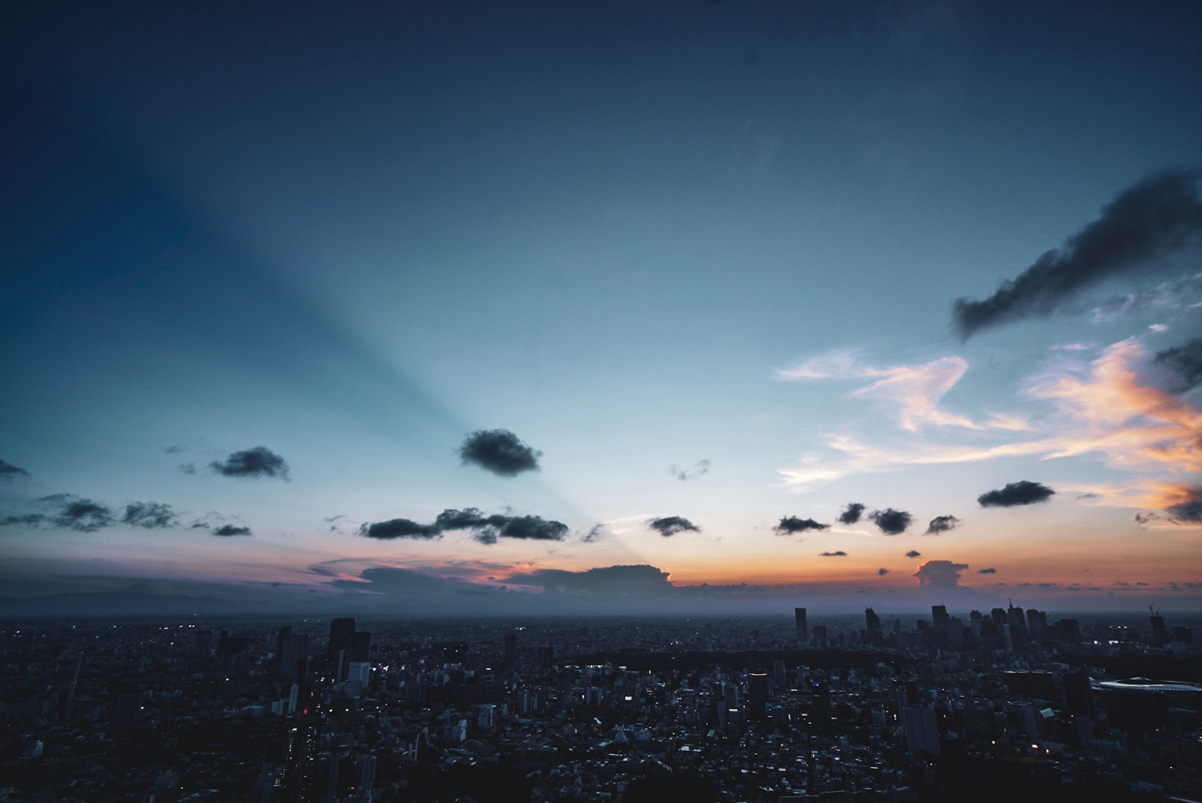 夕焼けの空に広がる都市のパノラマ風景と雲