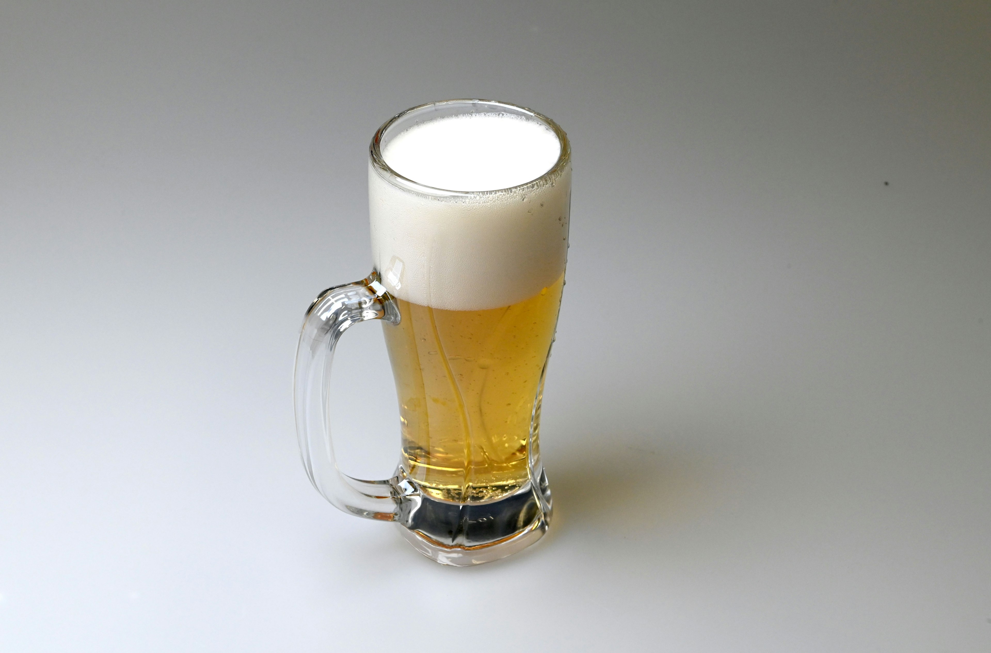 A glass of beer with a frothy head