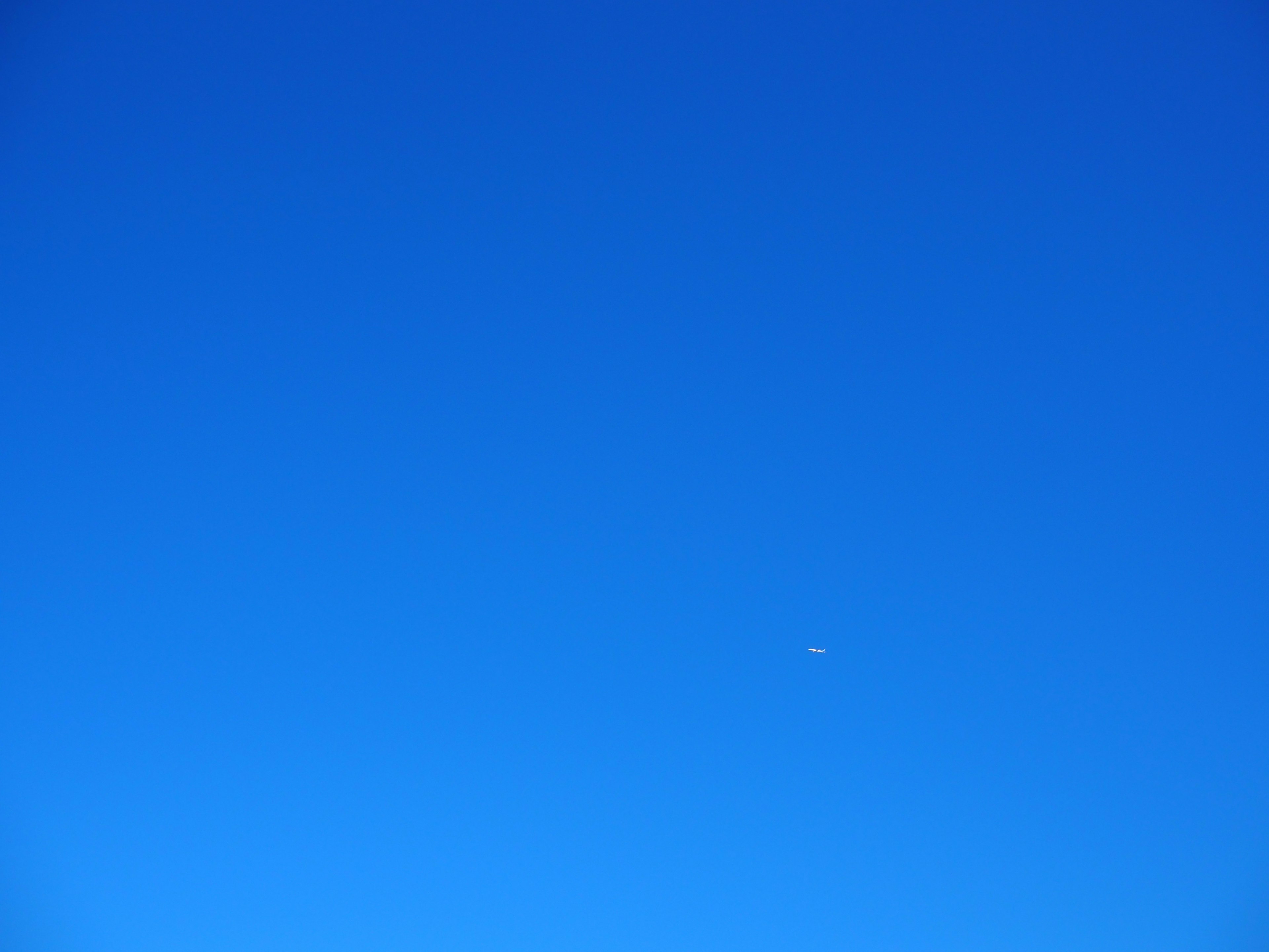 Ein klarer blauer Himmel mit einem kleinen weißen Punkt