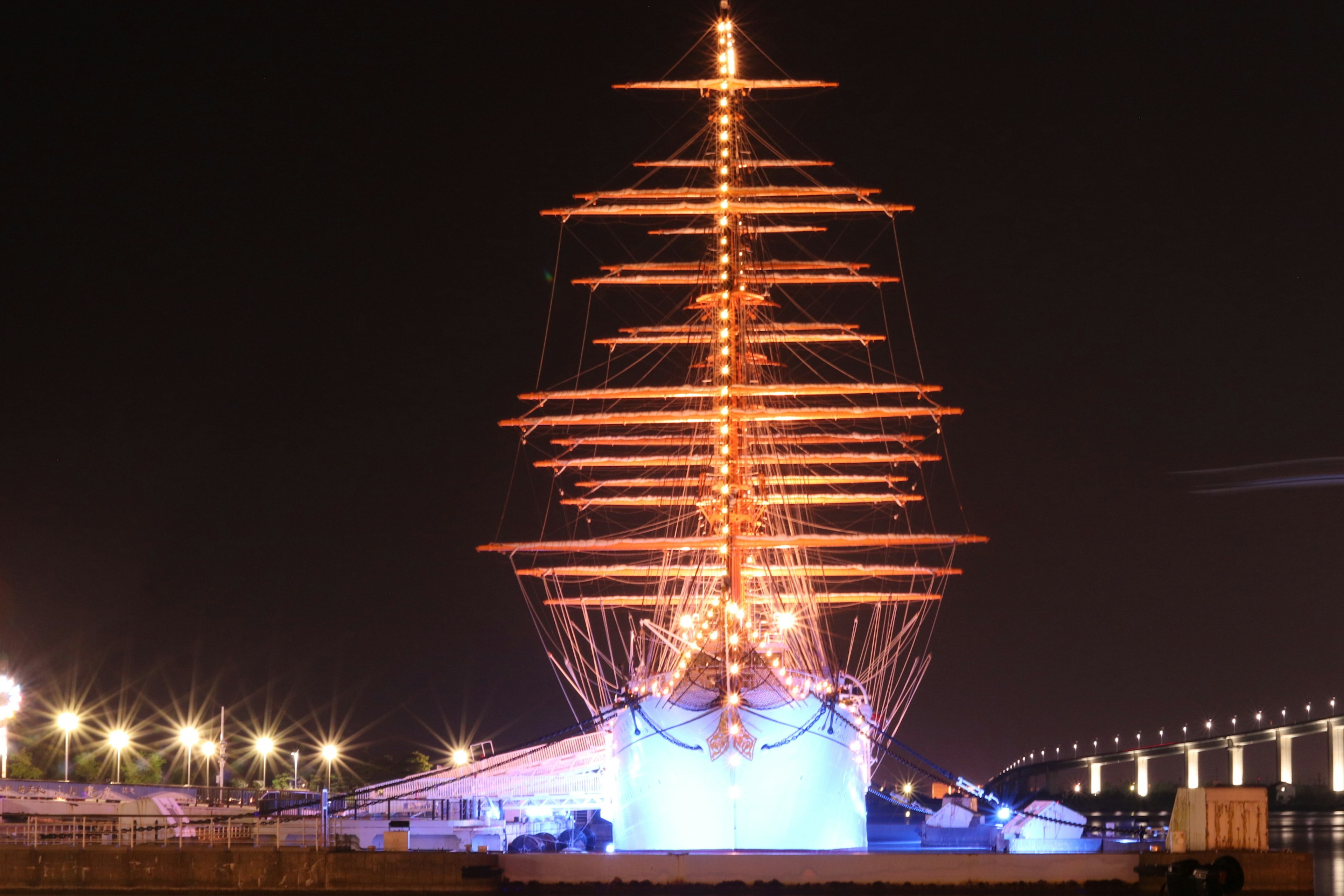 Illuminated tall ship at night in the harbor