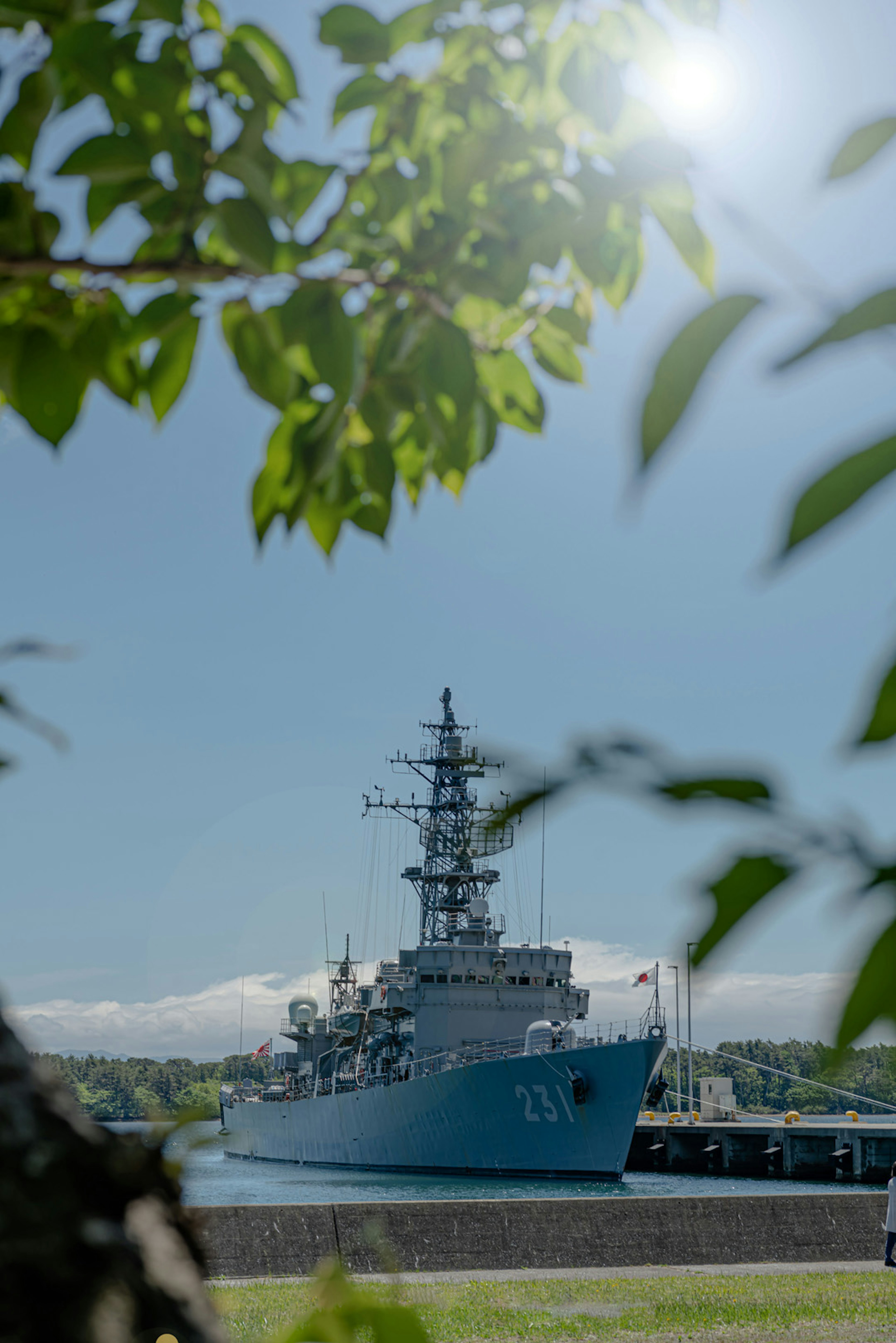 Blaues Kriegsschiff am Kai unter klarem Himmel