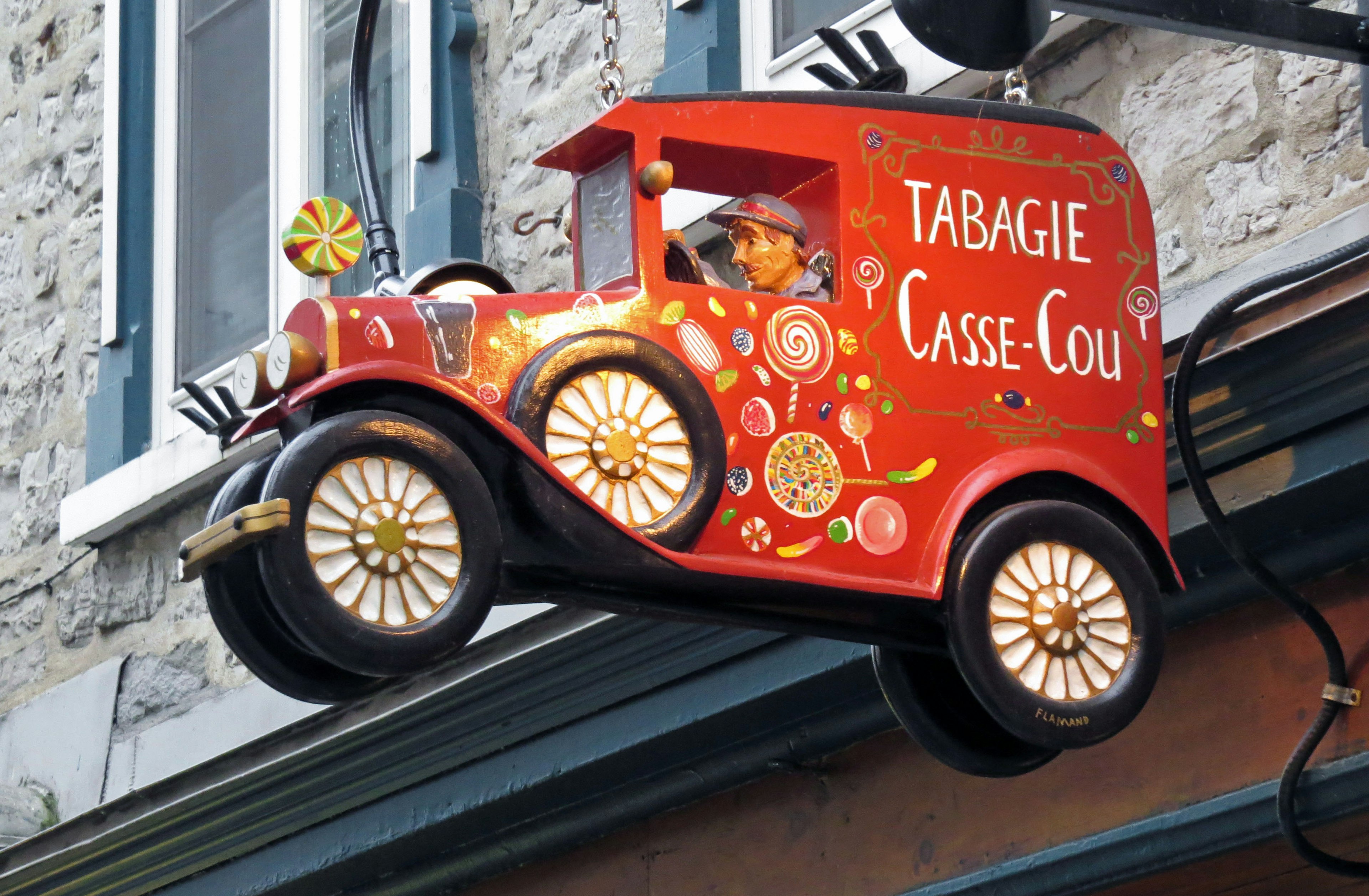 Decorative red car sign hanging above a store