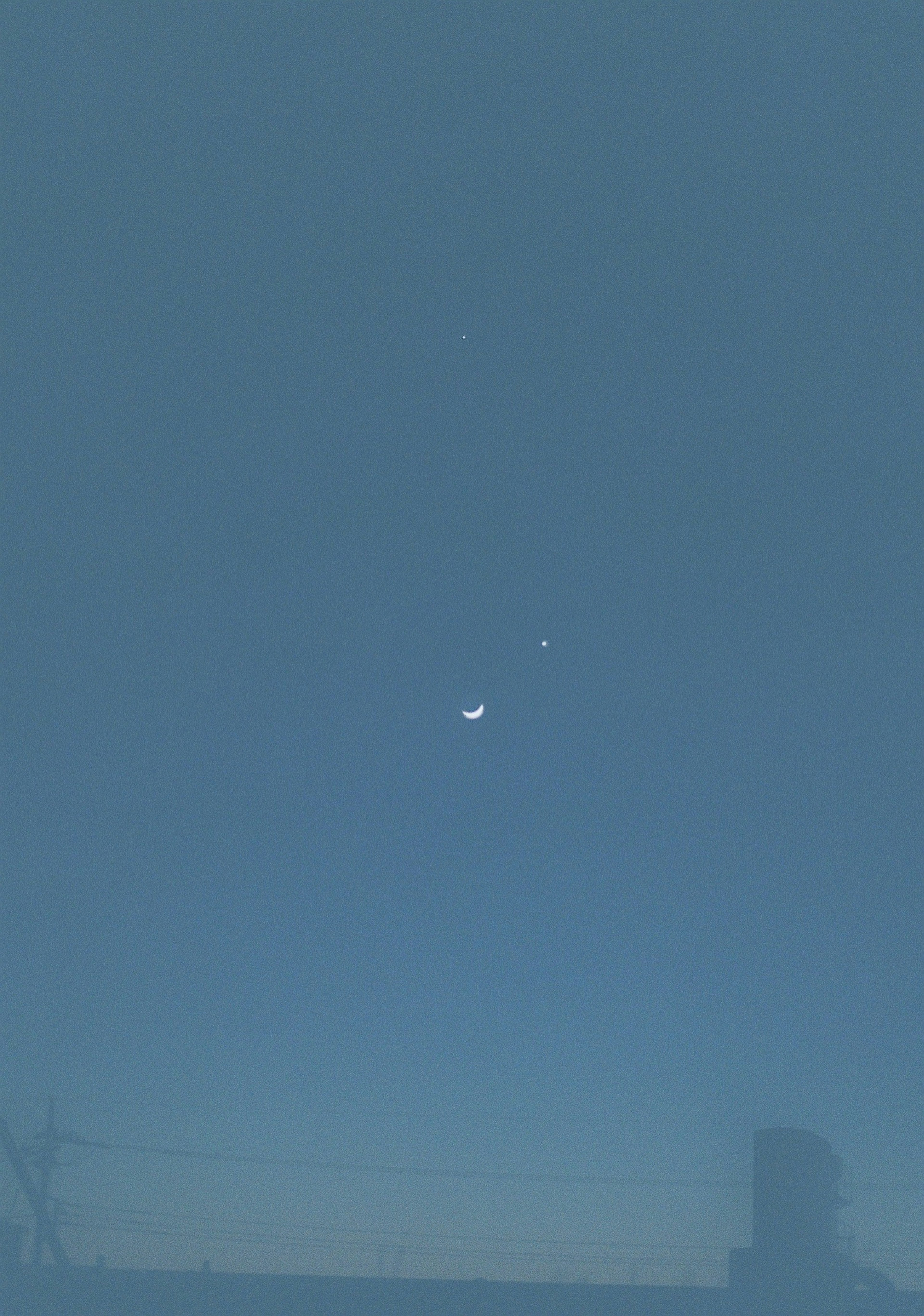 Lune croissante et deux étoiles dans un ciel bleu