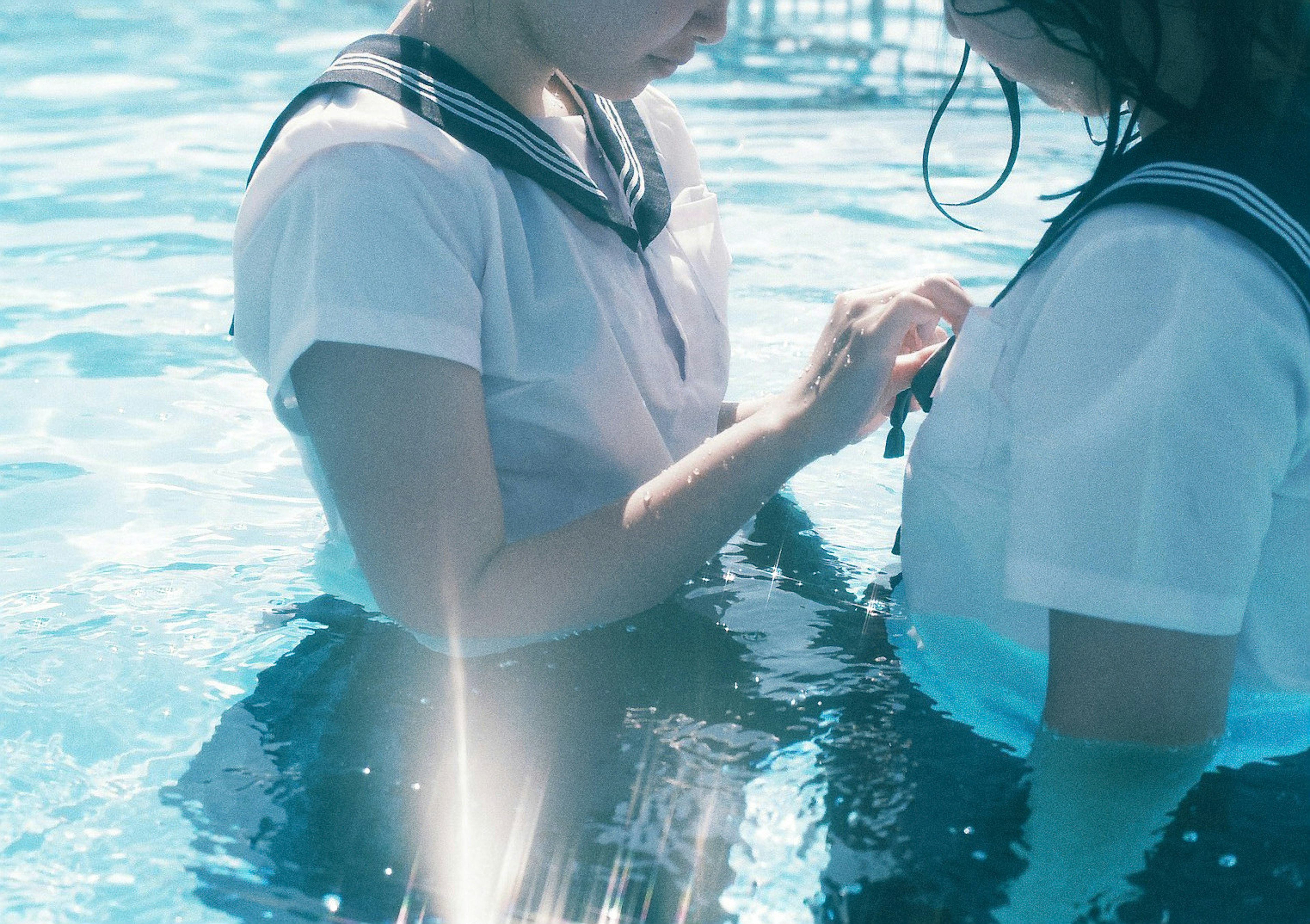 Two students in uniforms standing in water