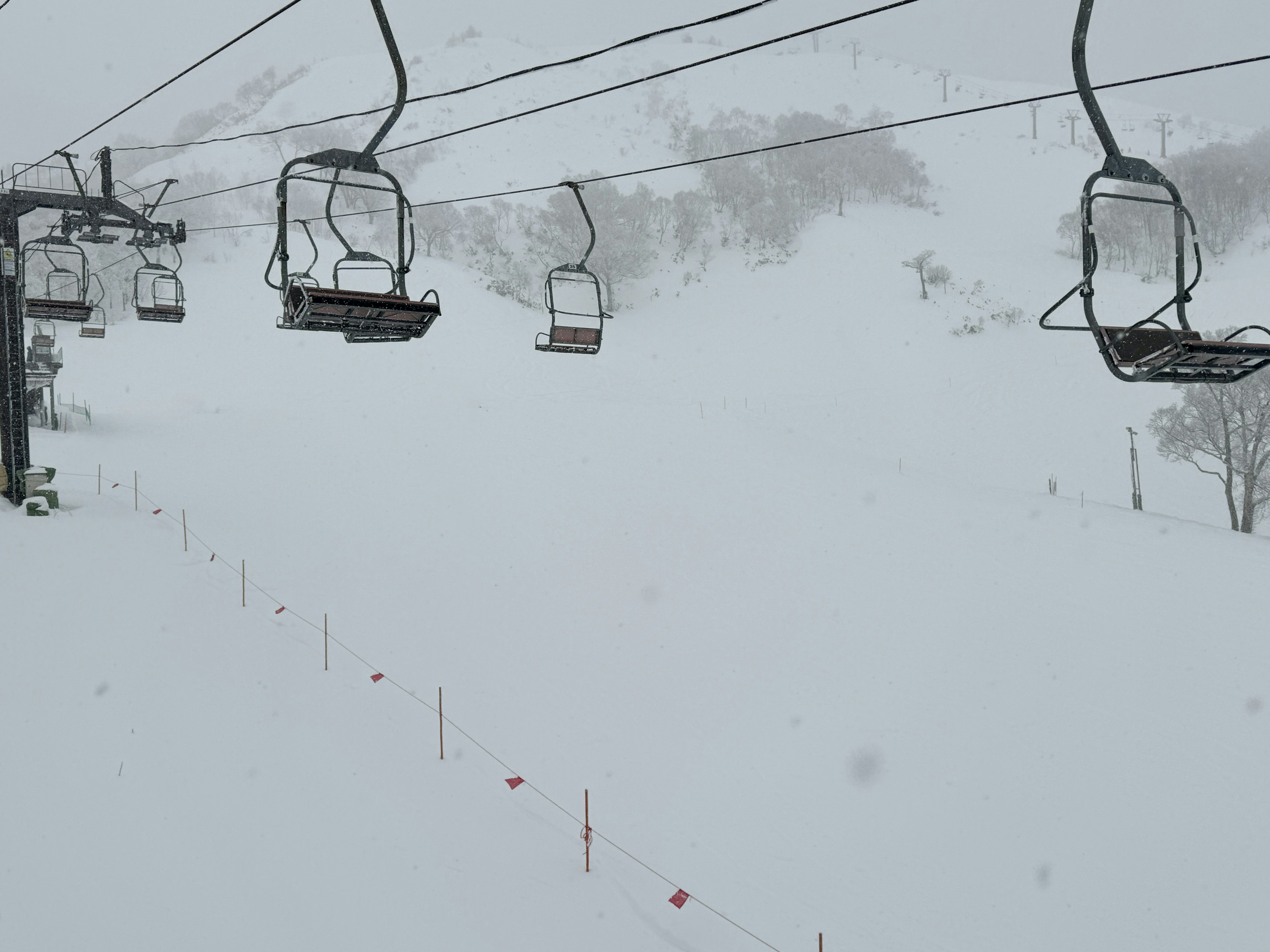 Skilift in einer schneebedeckten Landschaft mit starkem Schneefall