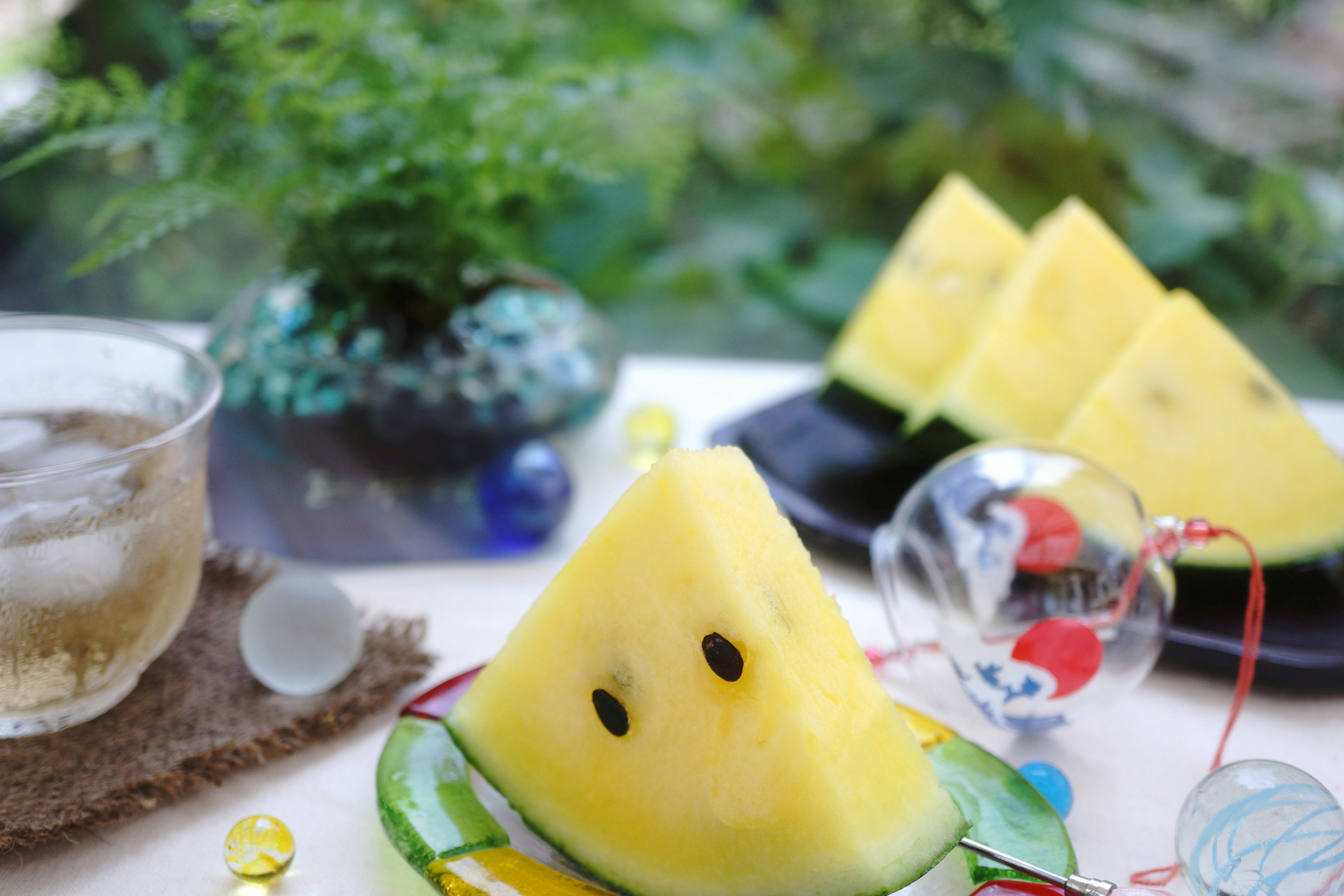 Gelbe Wassermelonenstücke mit einem erfrischenden Getränk auf einem Tisch