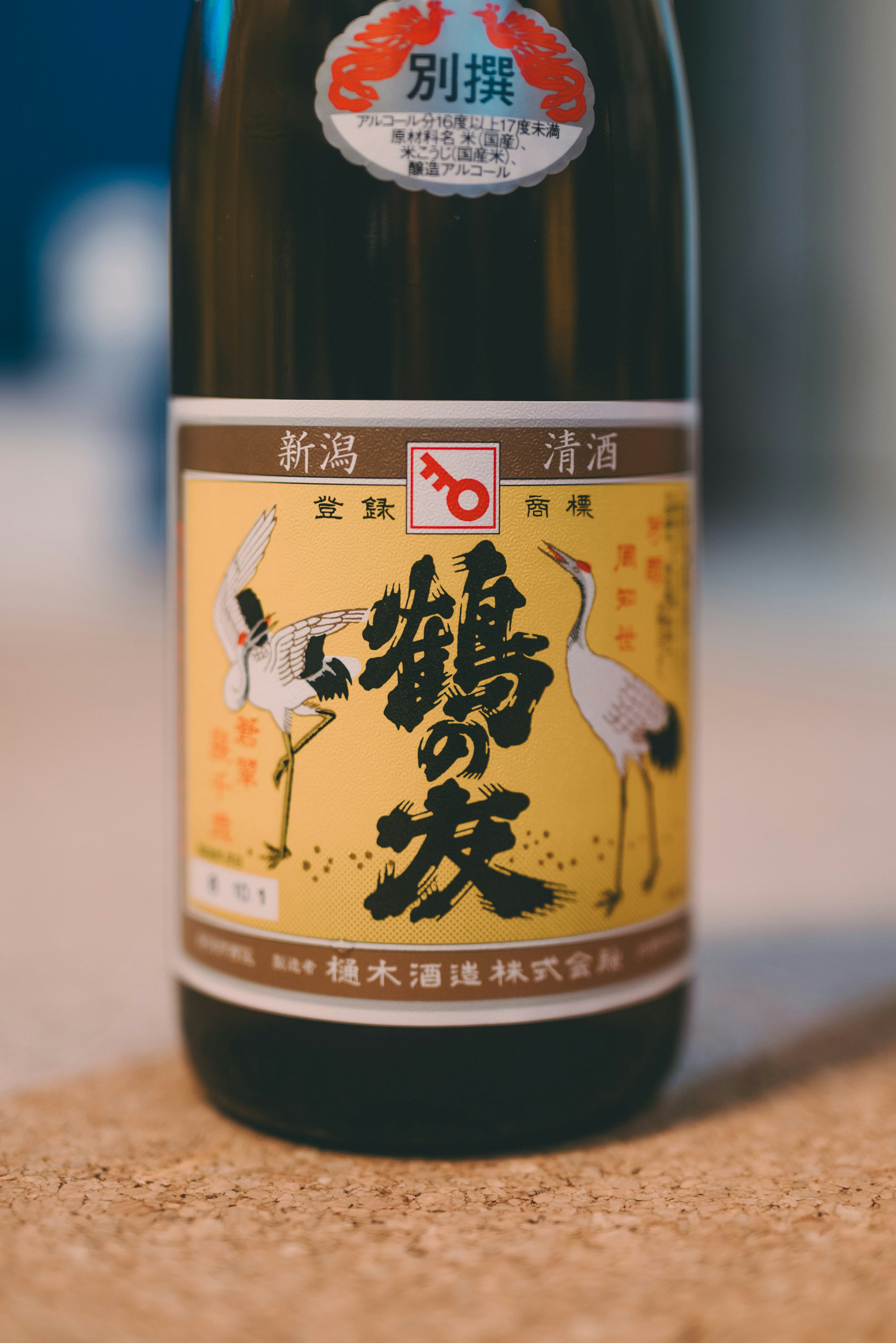 Yellow labeled sake bottle featuring crane illustrations