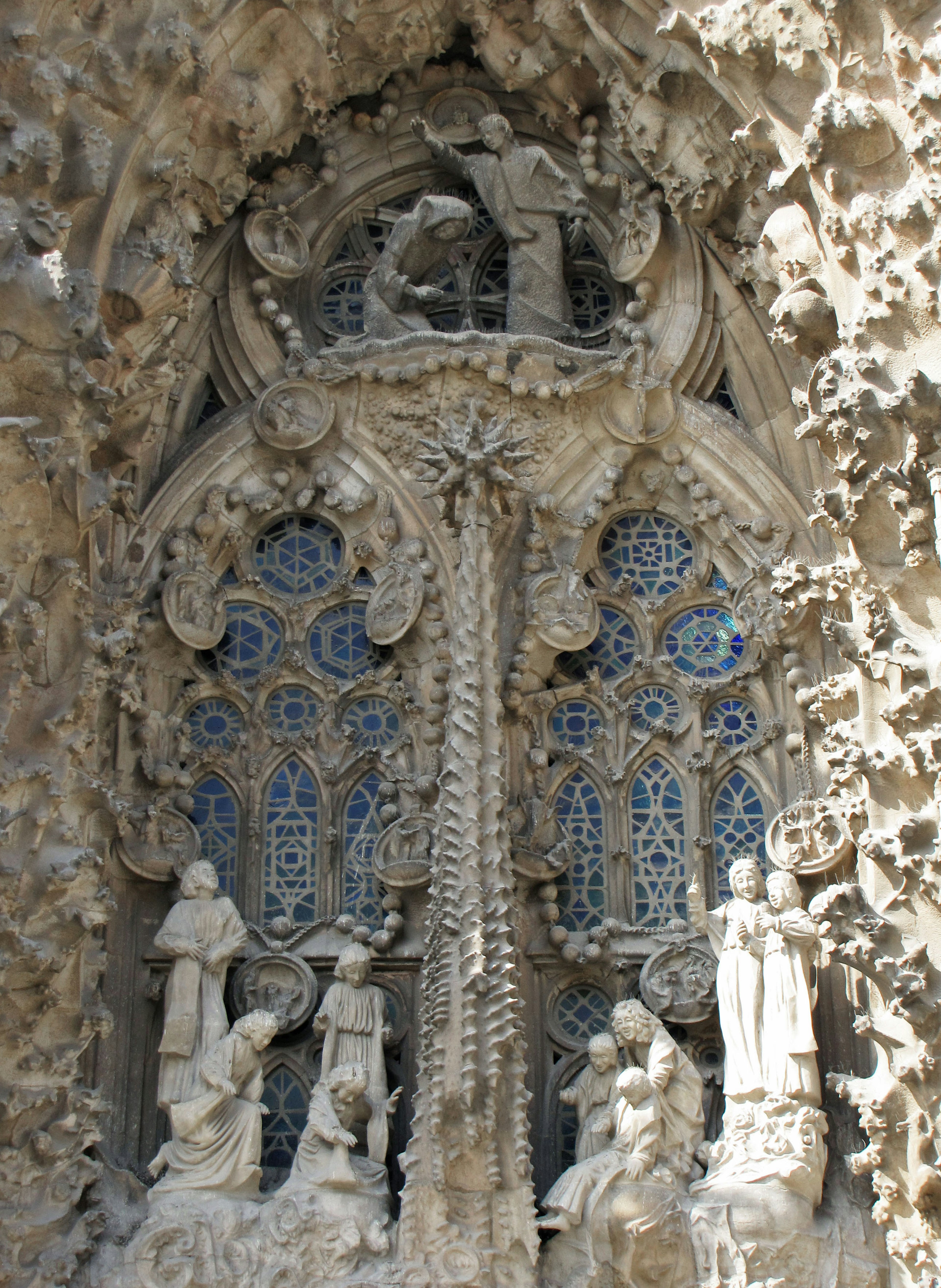 Detailliertes skulptiertes Fenster der Sagrada Familia mit blauen Buntglasfenstern