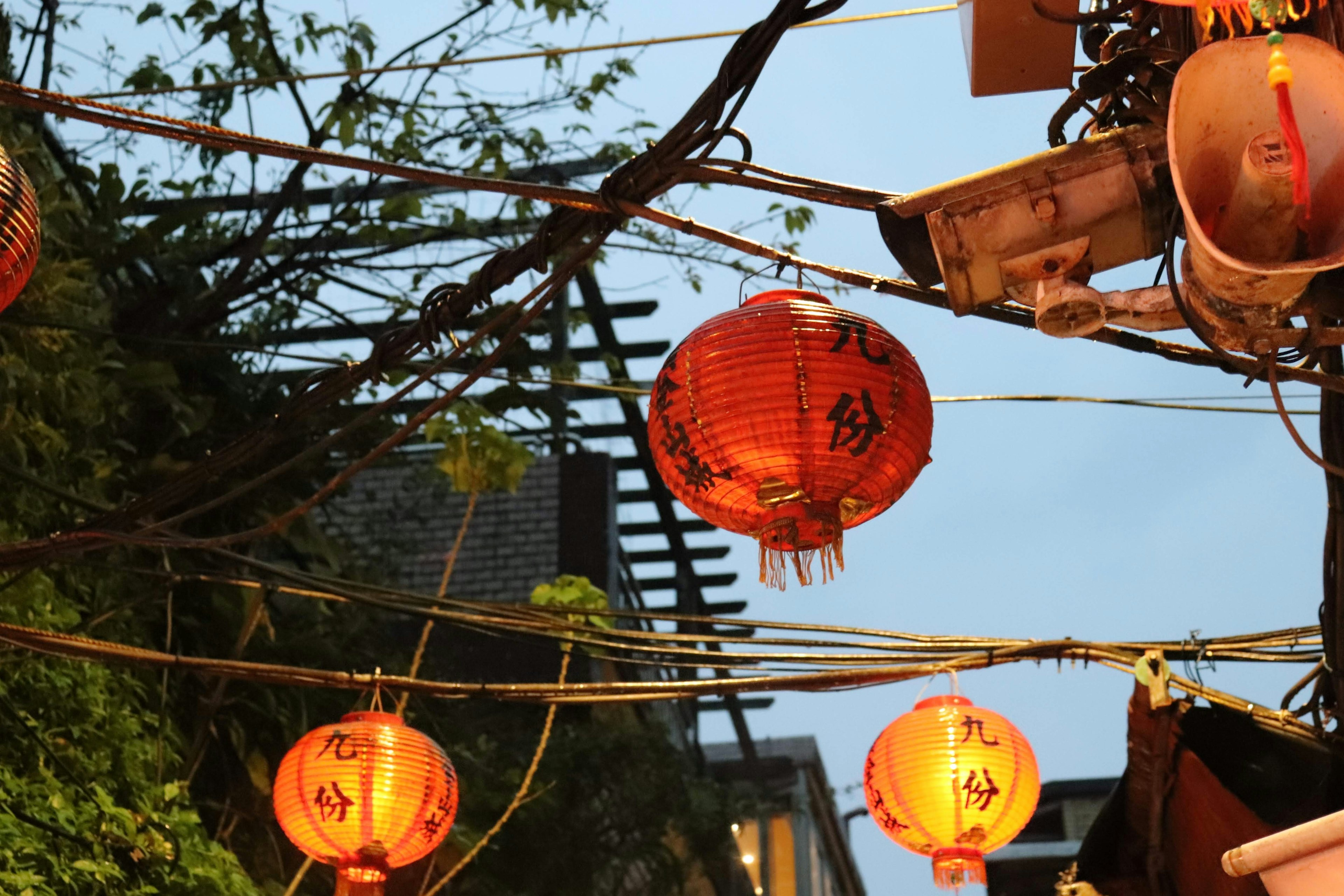 Row of red lanterns hanging against a twilight sky