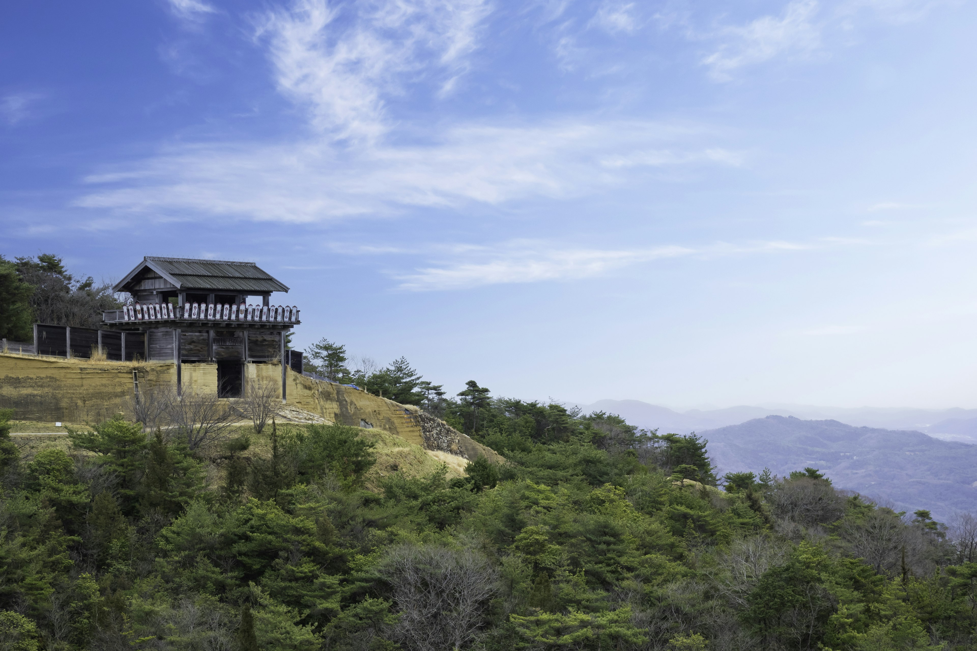 Traditional Japanese building on a hillside with blue sky