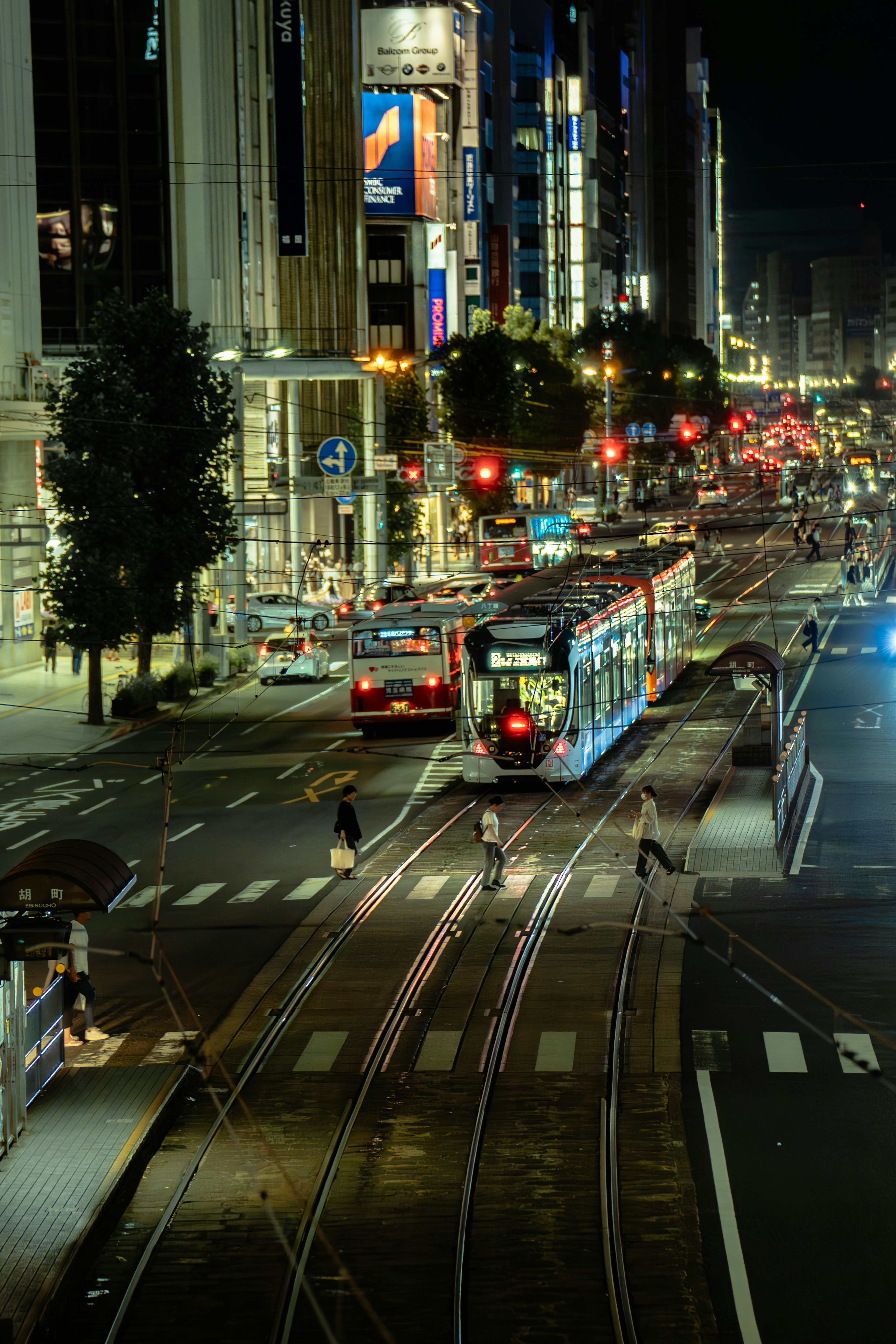 夜の都市のトラムと交通の様子