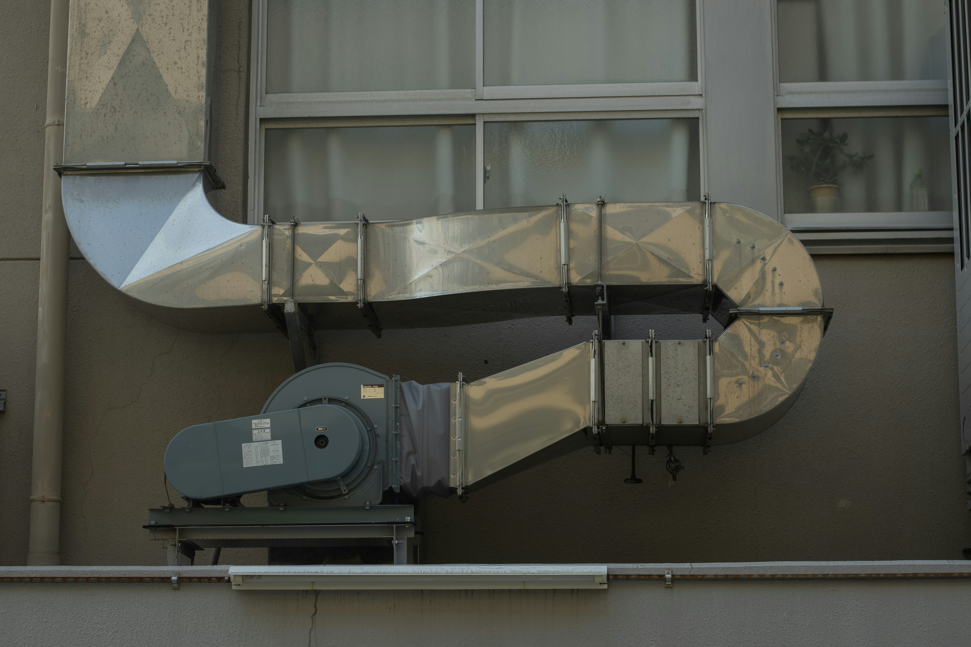 Duct de ventilation en métal fixé à un mur