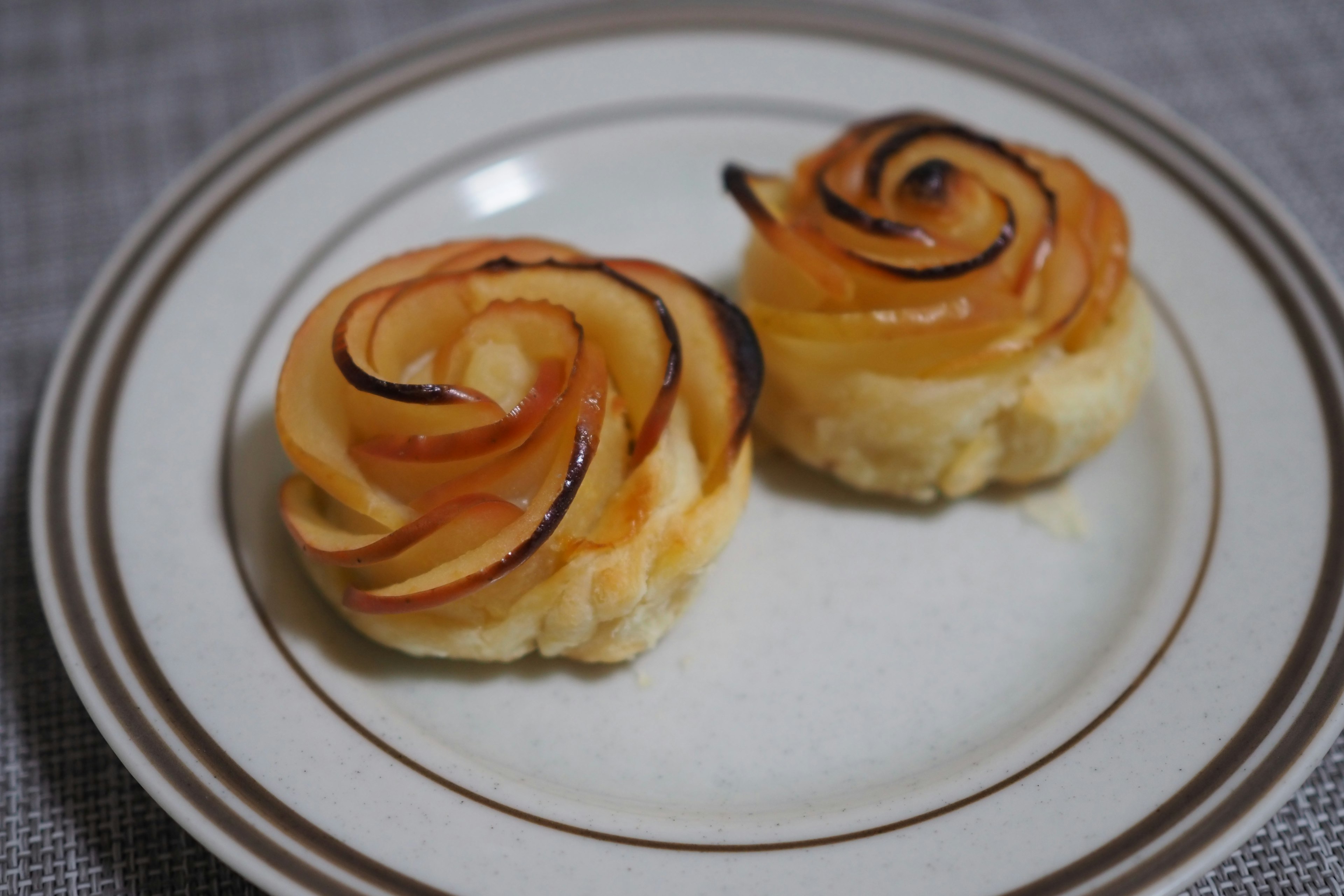 Deux pâtisseries en forme de rose sur une assiette blanche