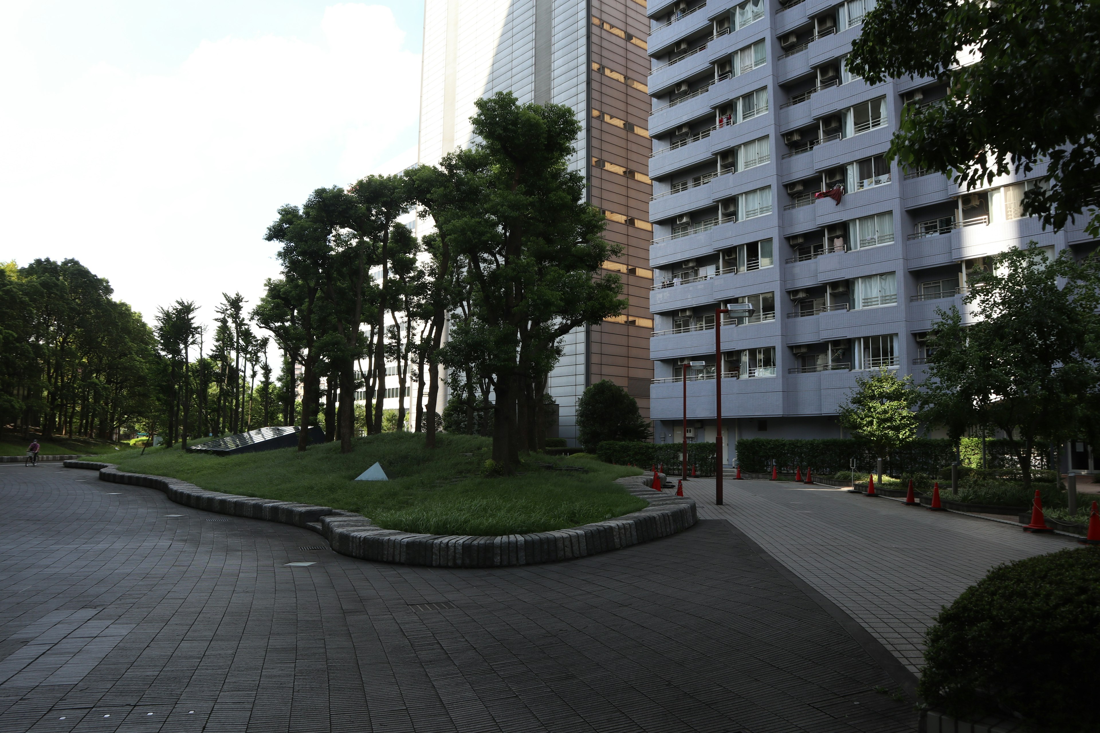 Lush park and walkway near a tall building