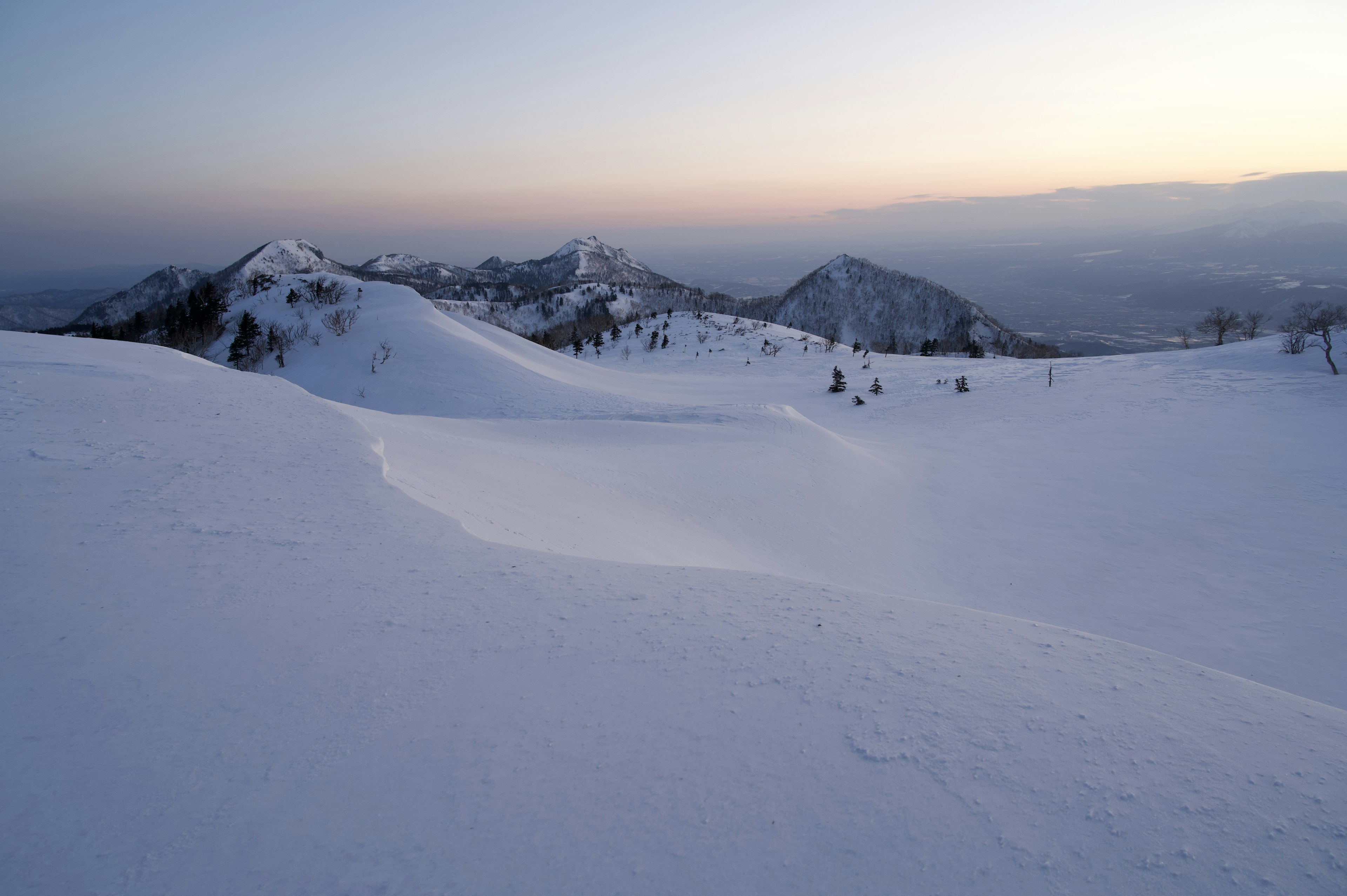 Montagne innevate sotto un cielo crepuscolare