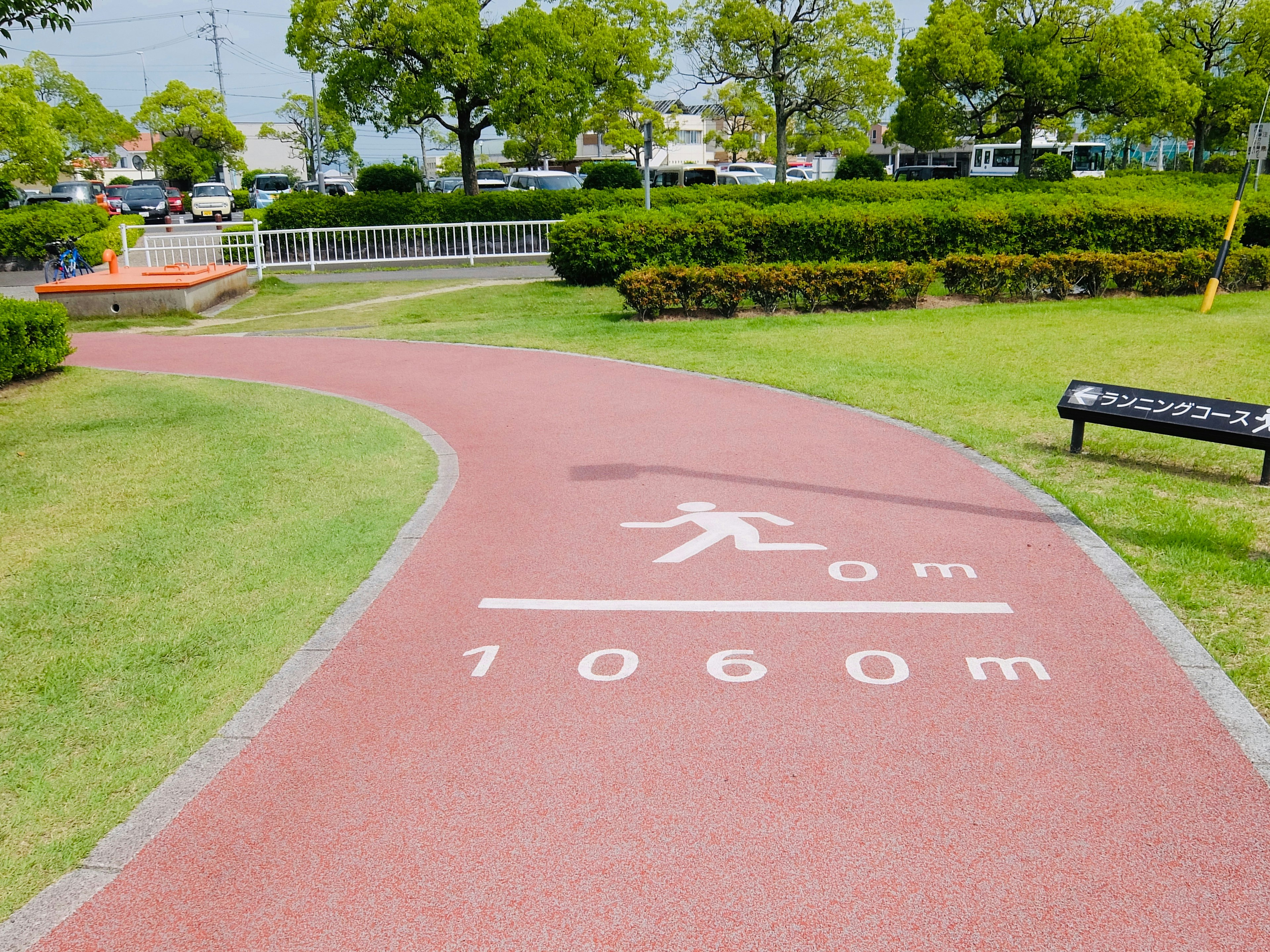 公園內的跑步道，紅色表面上的距離標記