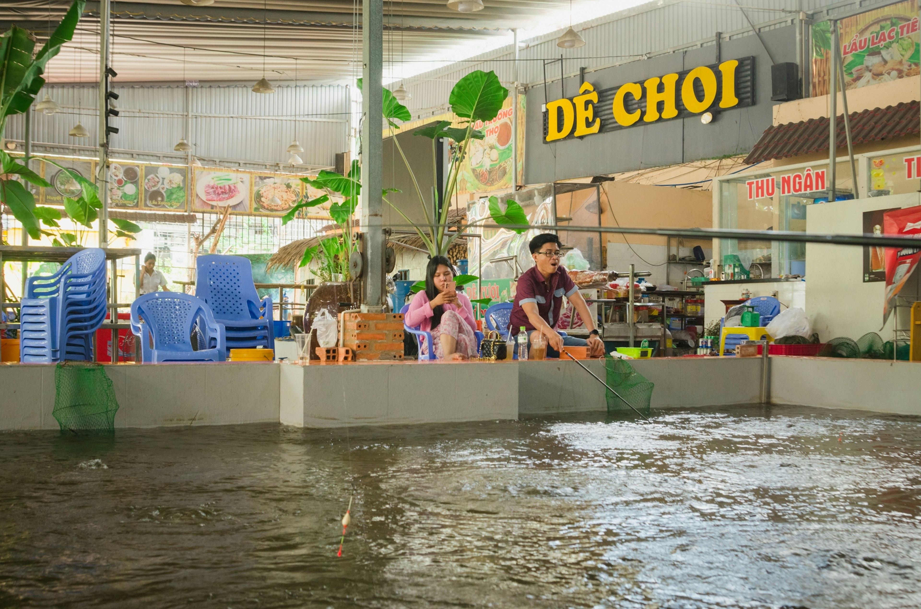 Mercado interior con niños y adultos jugando rodeados de agua