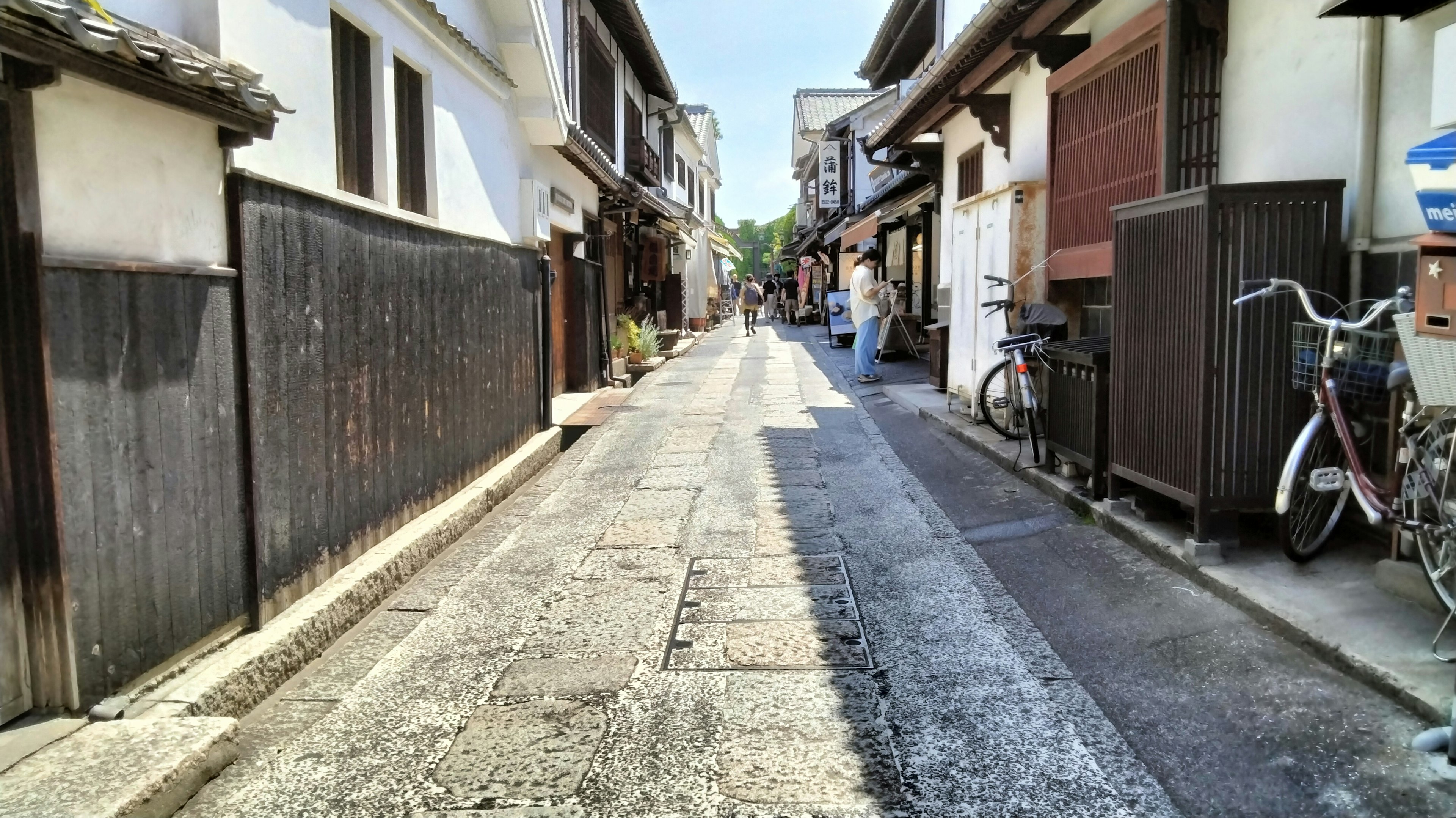 Calle estrecha flanqueada por casas japonesas tradicionales