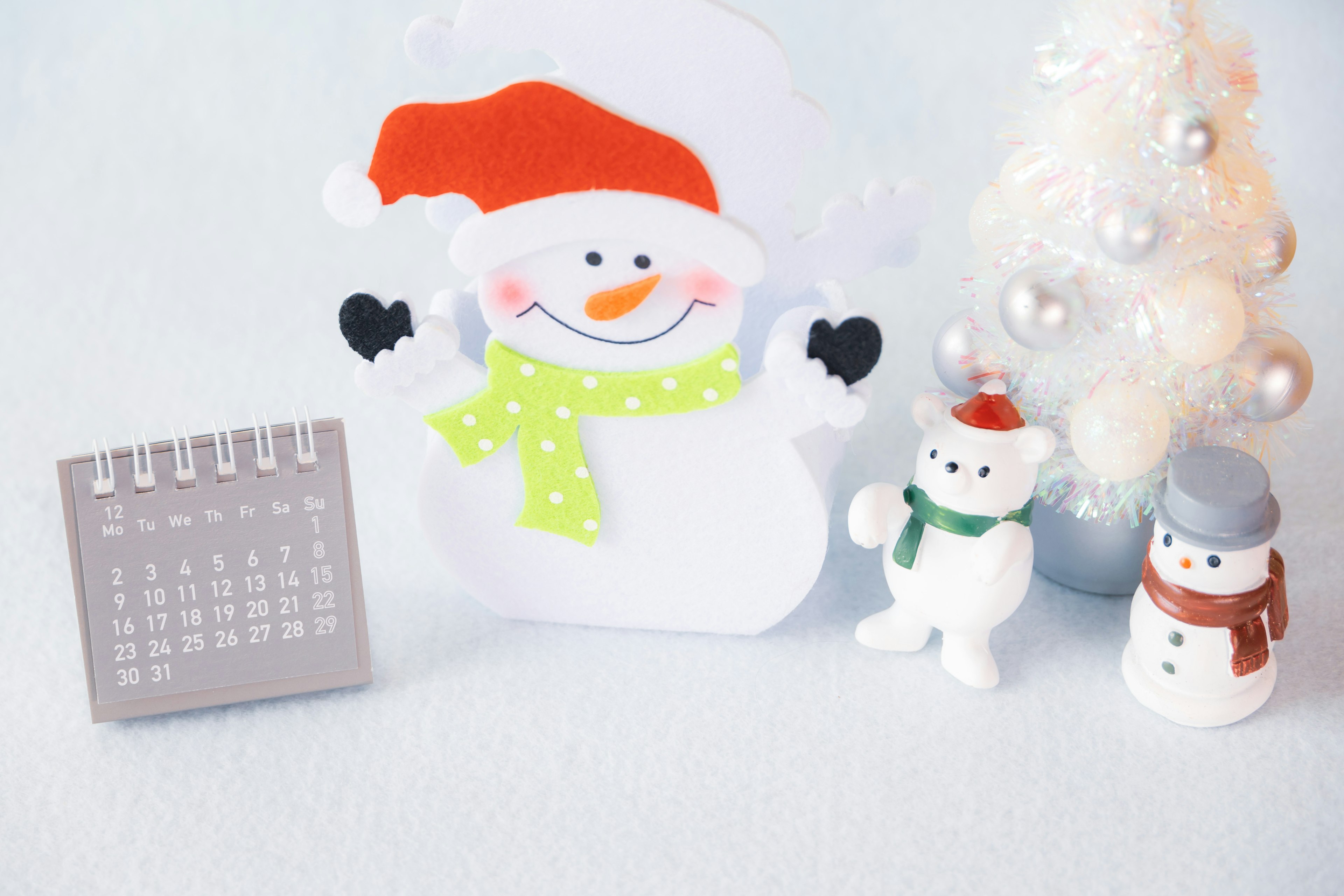 Winter decoration featuring a snowman, a calendar, and a Christmas tree