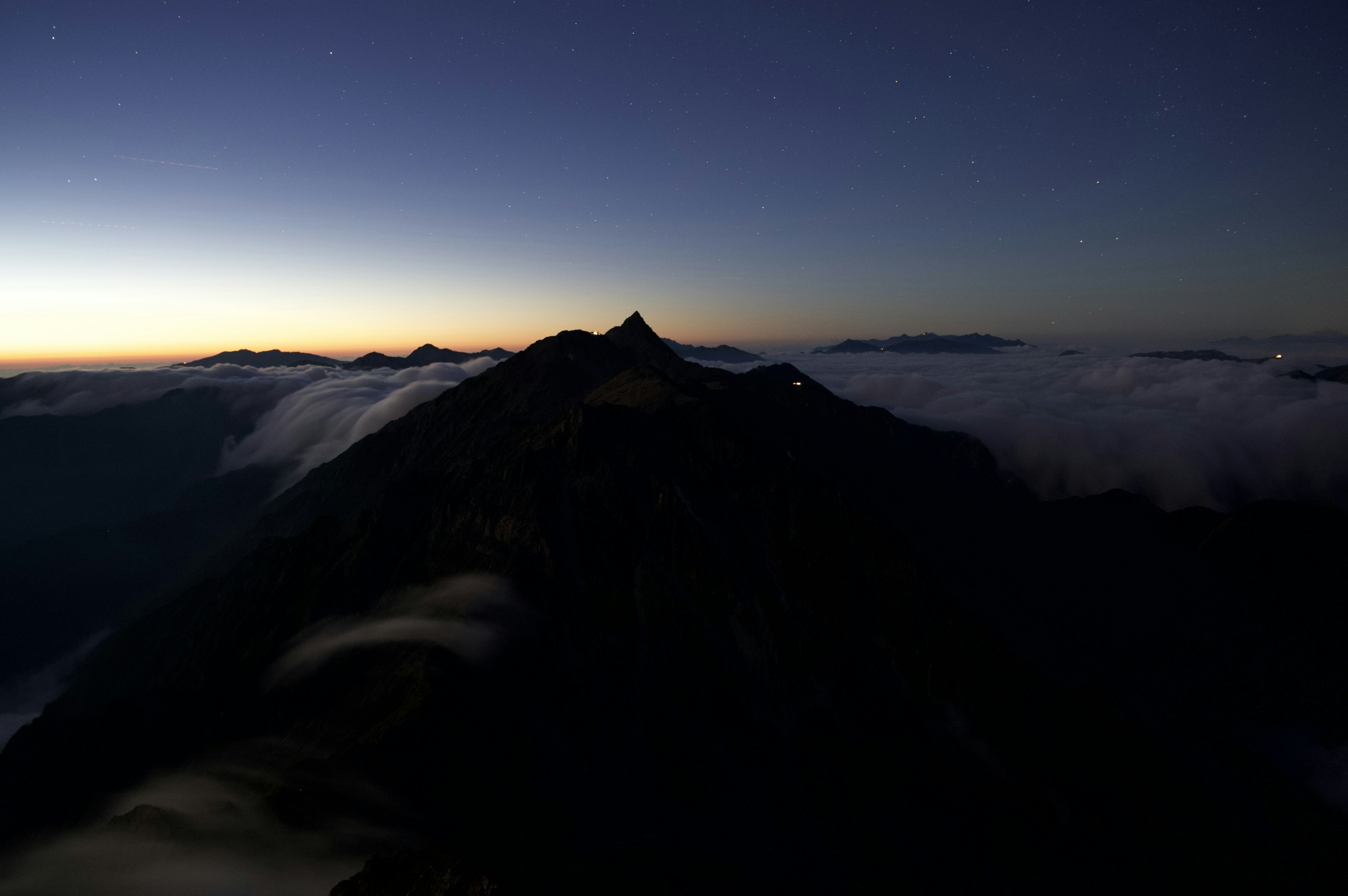 Silhouette eines Berges mit einem Wolkenmeer bei Sonnenaufgang