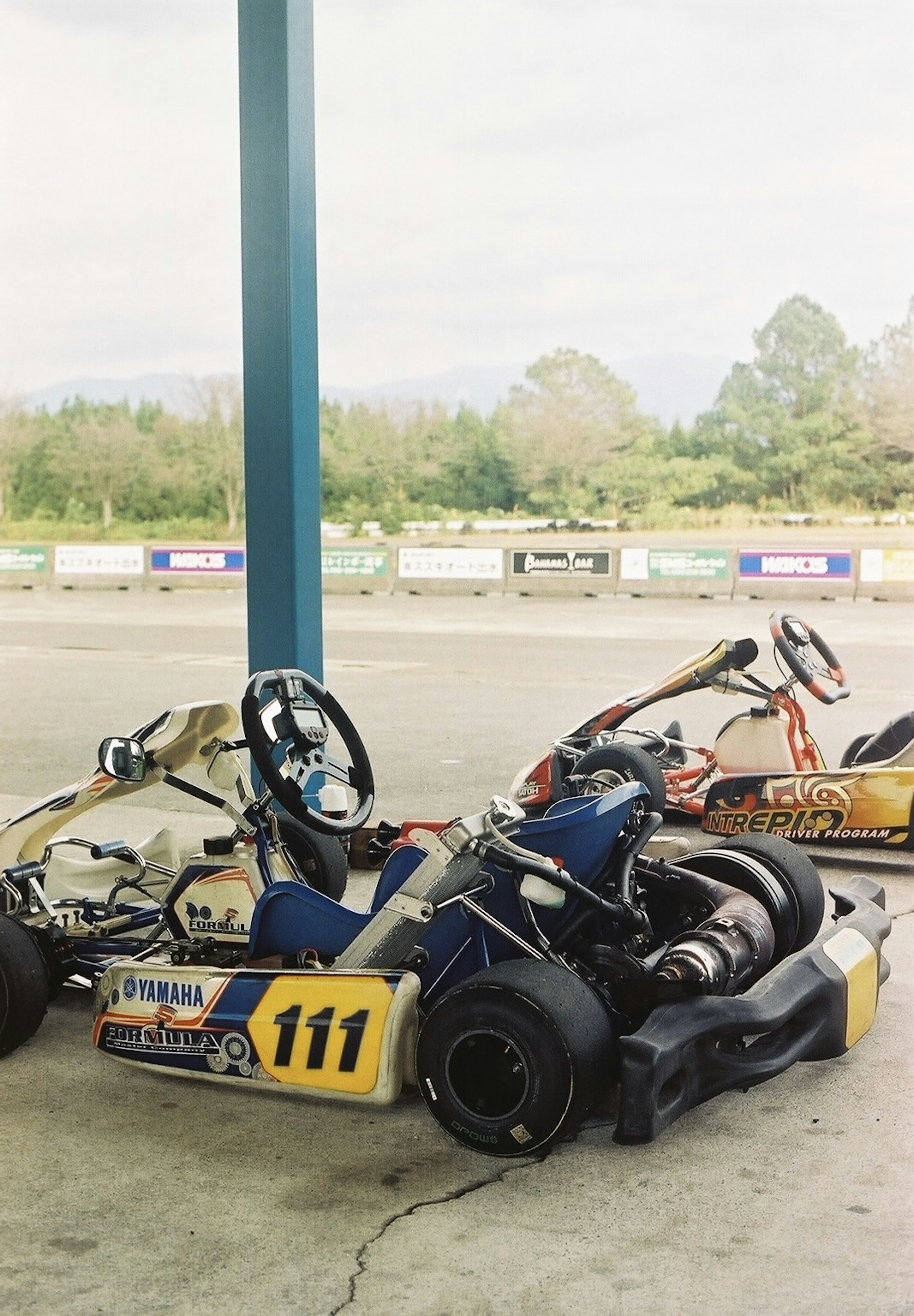 Go-karts parked under a shelter at a racing track