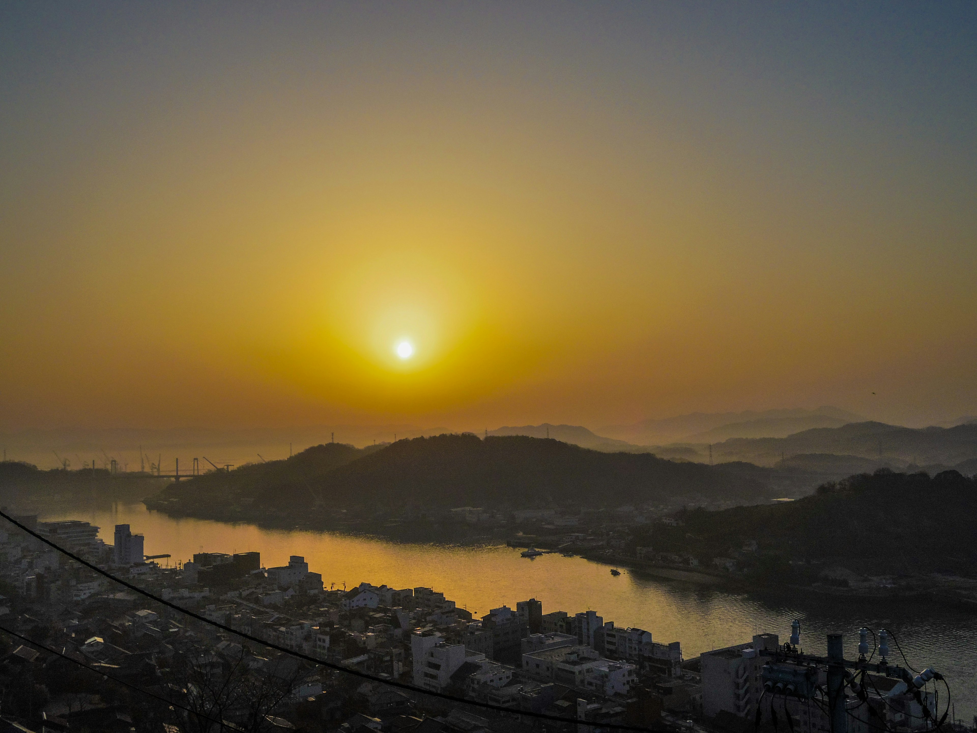 Lever de soleil sur une rivière avec des collines en arrière-plan