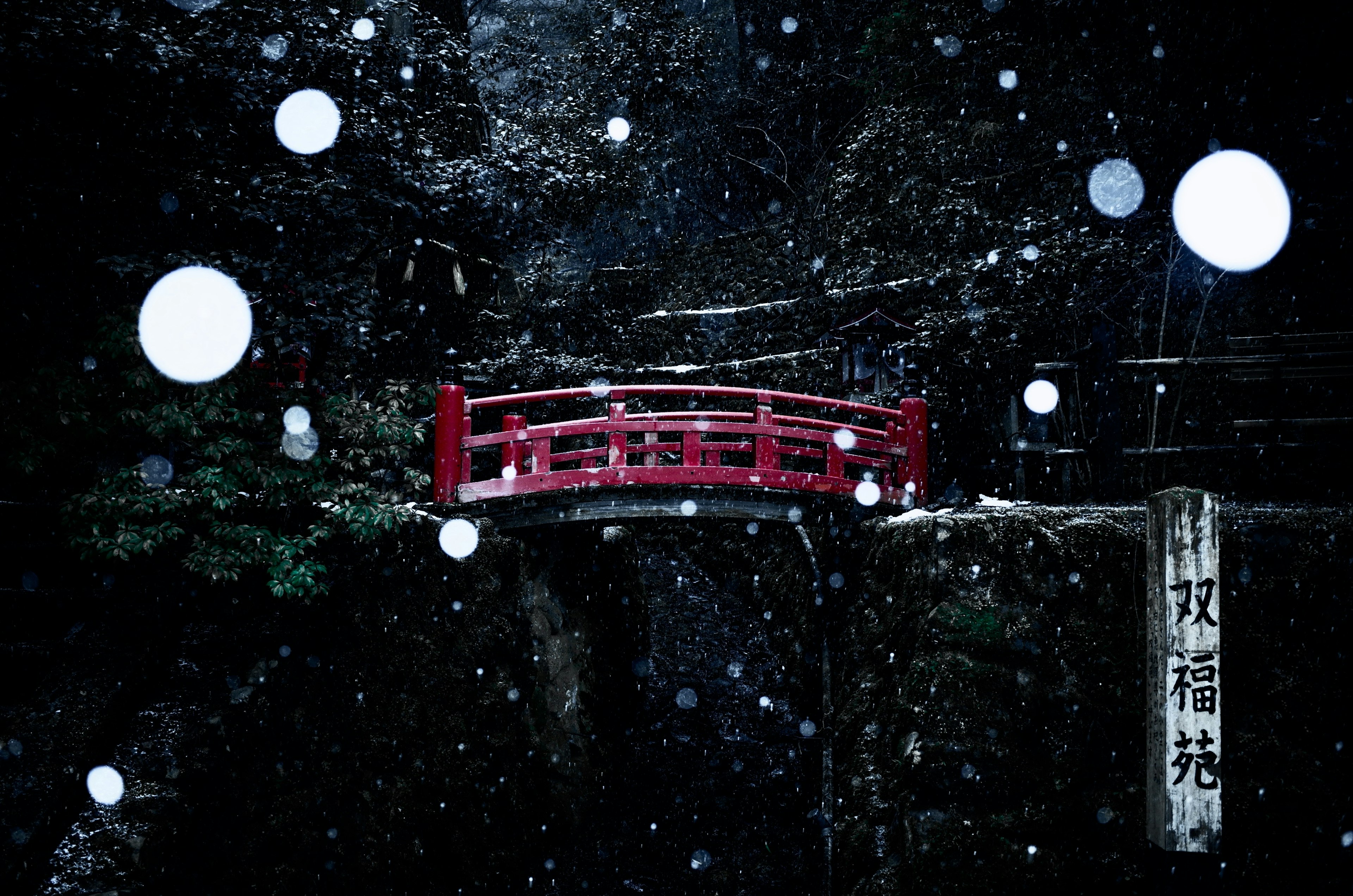 Eine rote Brücke umgeben von Schnee und natürlicher Landschaft