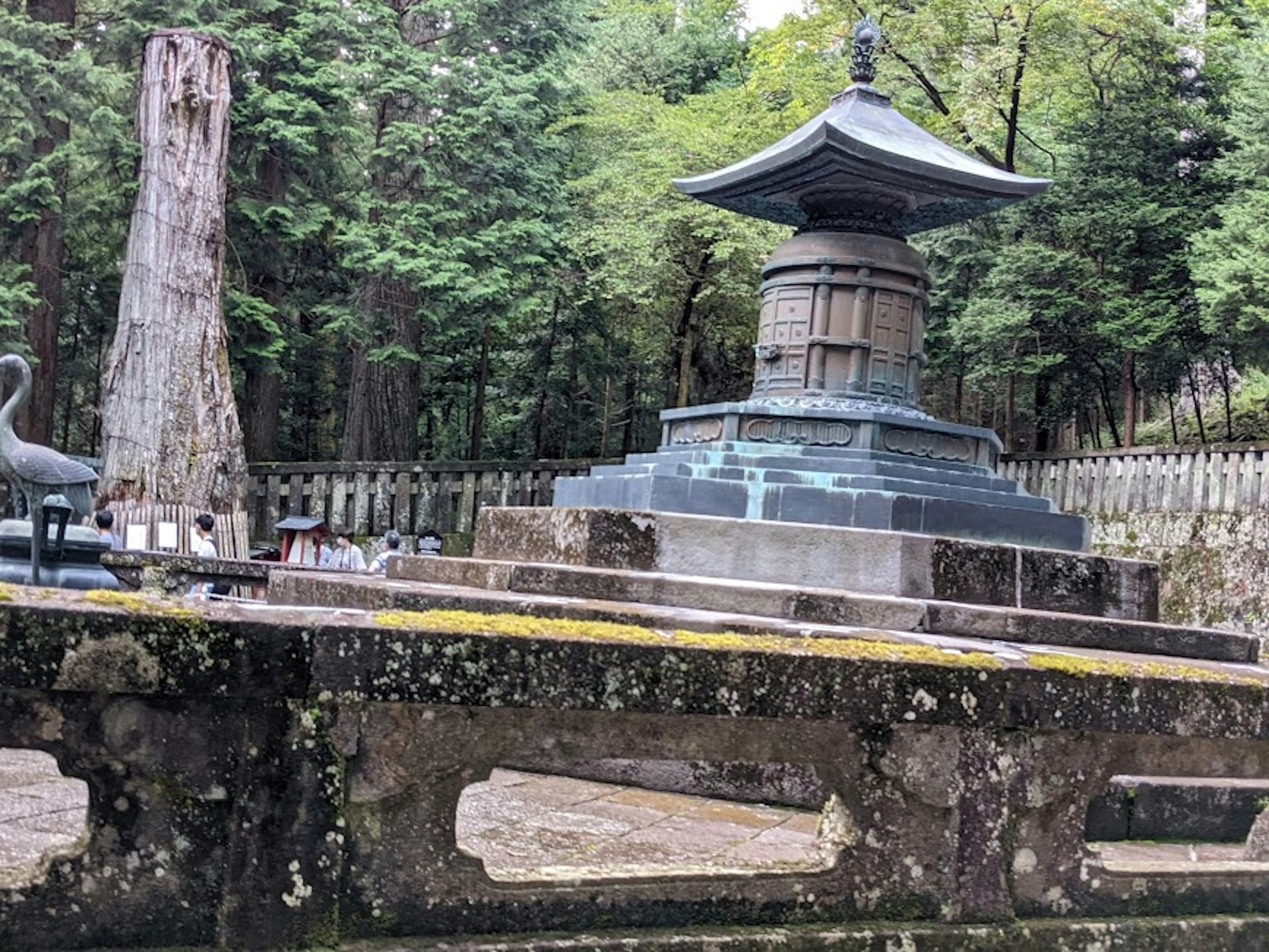 Ancient Buddhist tower surrounded by trees and stone bridge