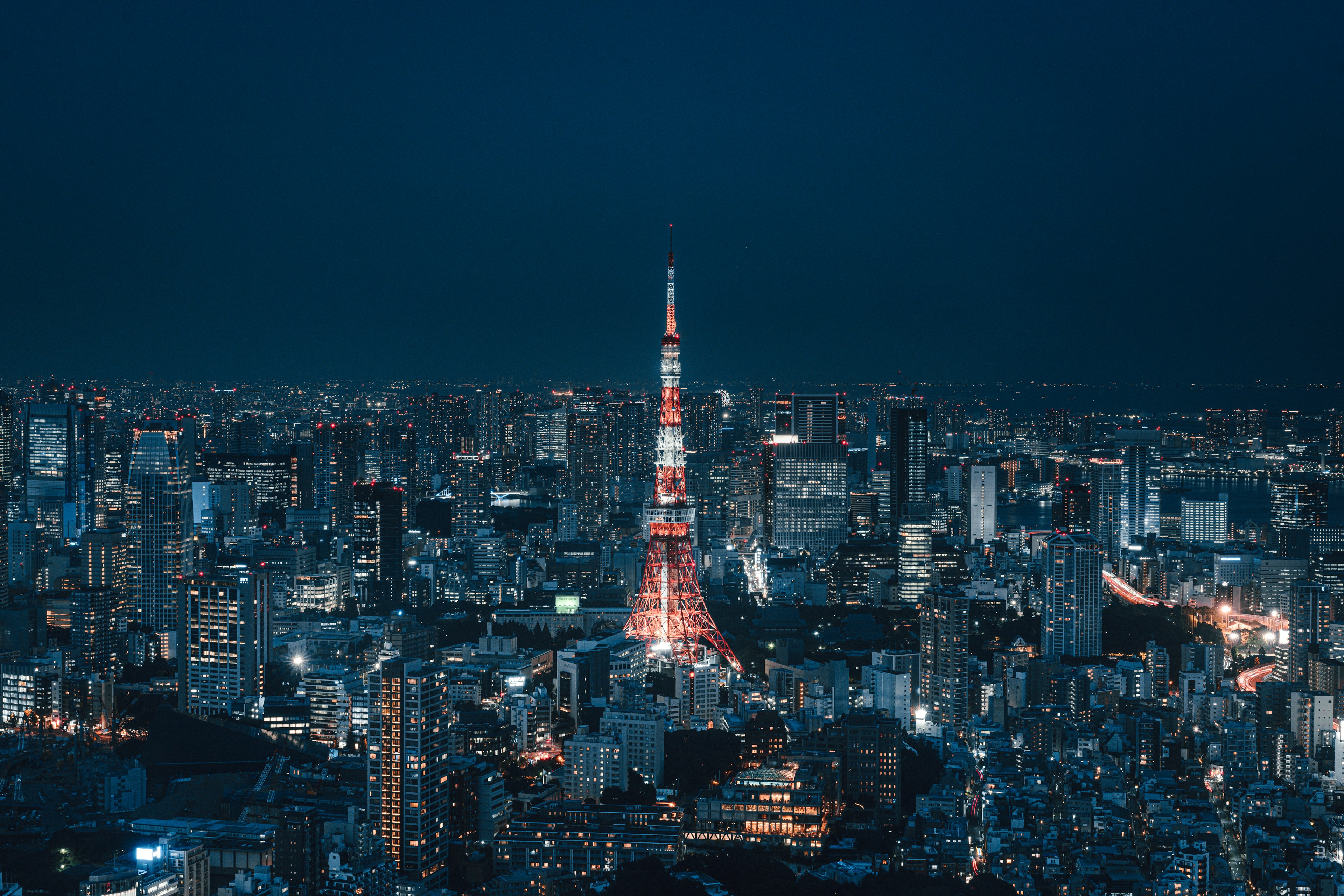 Tour de Tokyo illuminée la nuit avec une skyline urbaine vibrante