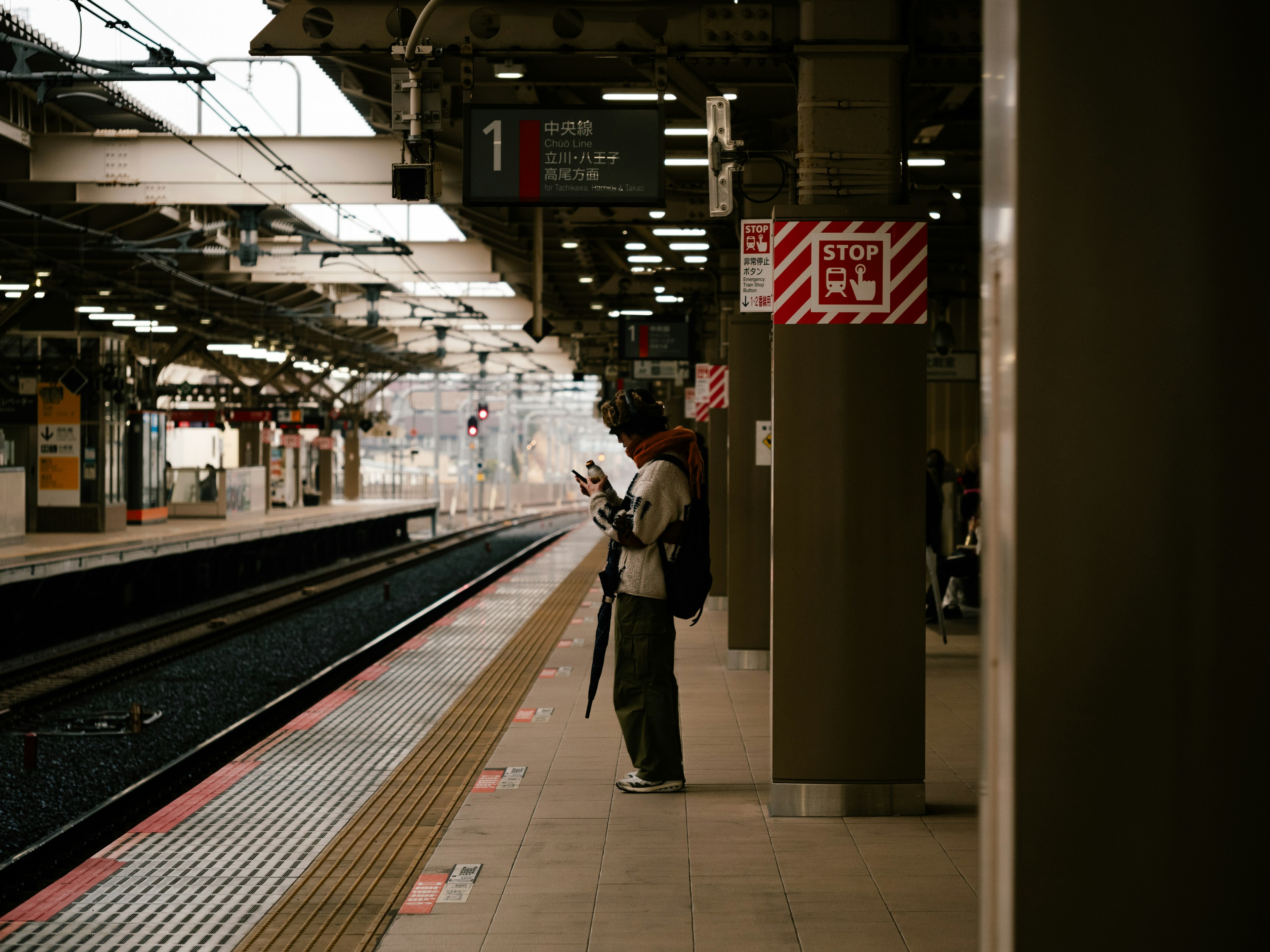 駅のプラットフォームに立つ人と列車の待機エリア