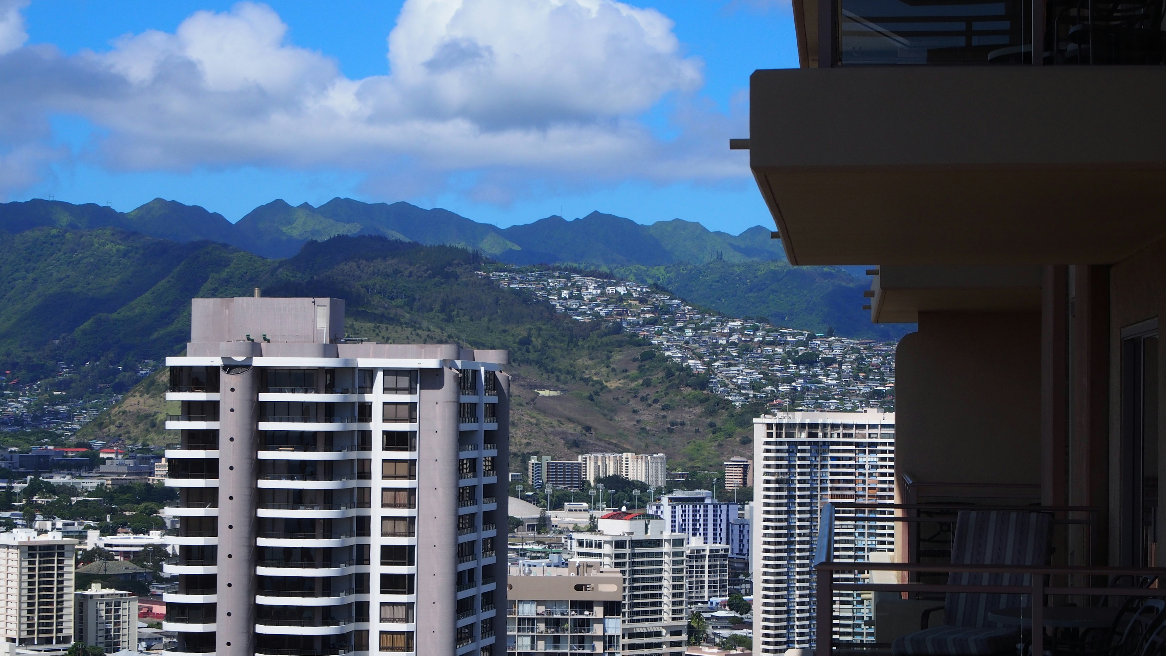 View of high-rise buildings against a bright blue sky with mountains in the background