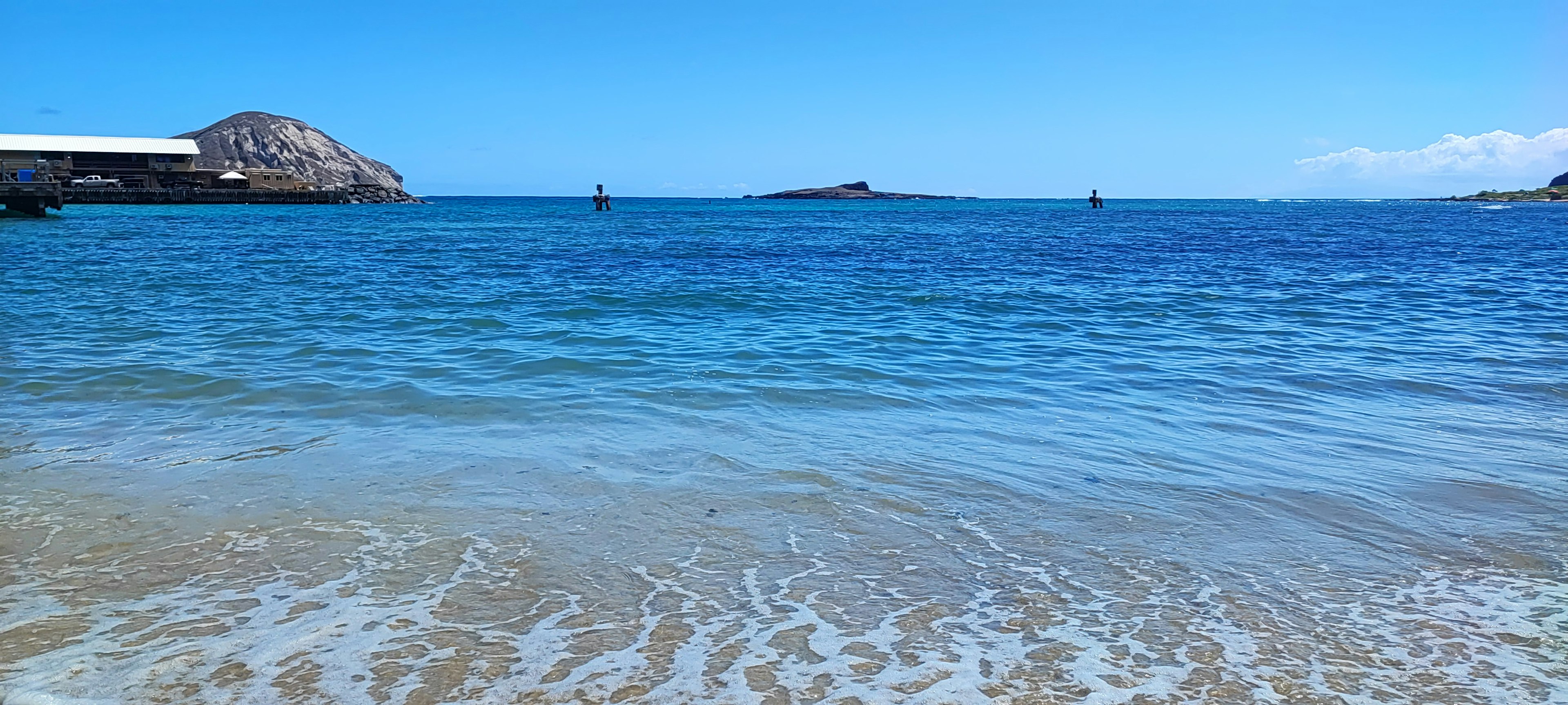 Panoramablick auf einen ruhigen blauen Ozean mit sanften Wellen und fernen Inseln